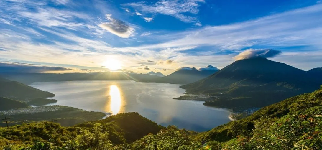 Sunrise over Lake Atitlán, surrounded by mountains and clouds, Guatemala.