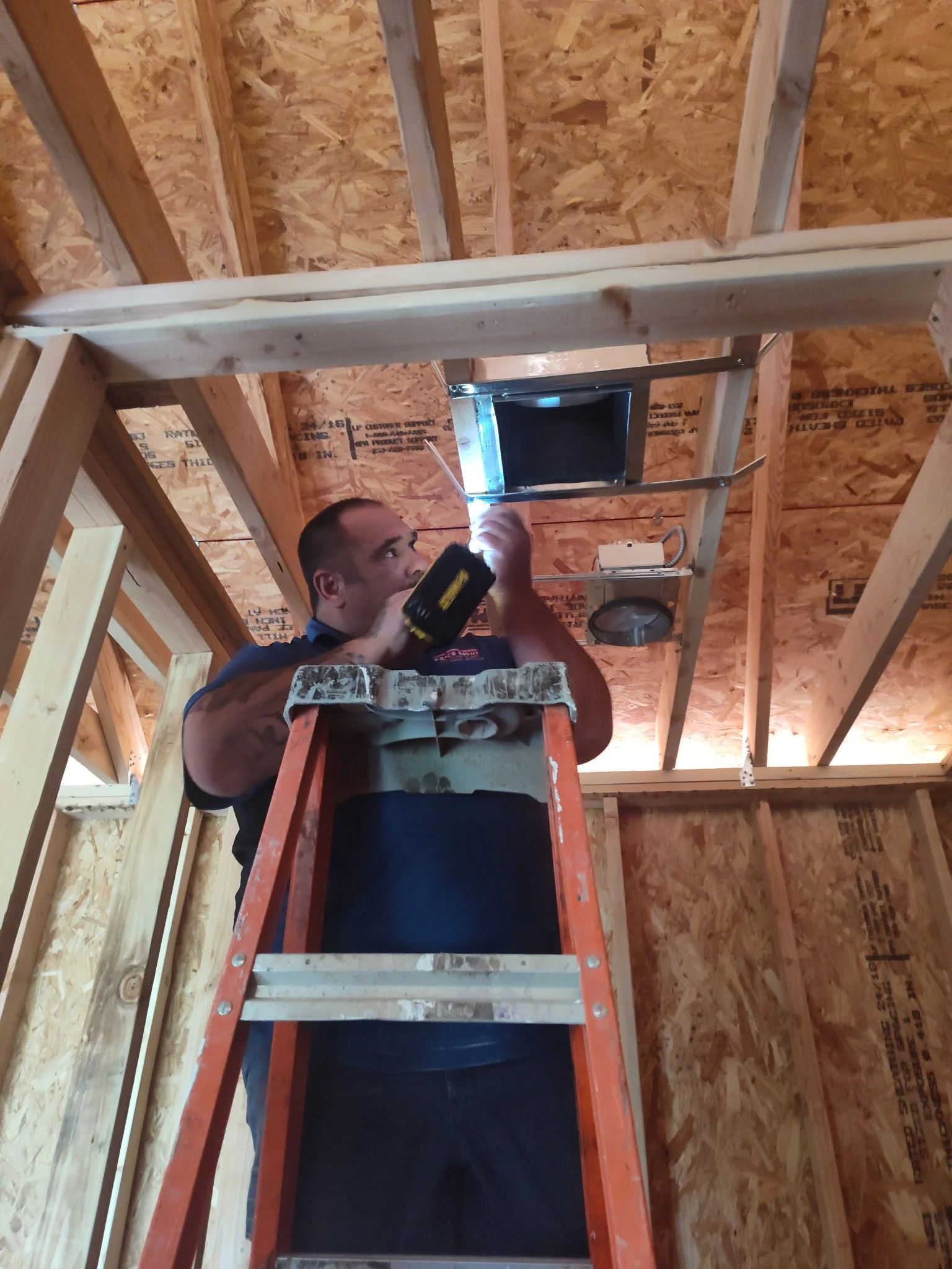 HVAC technician installing ductwork in residential attic in Central Oklahoma
