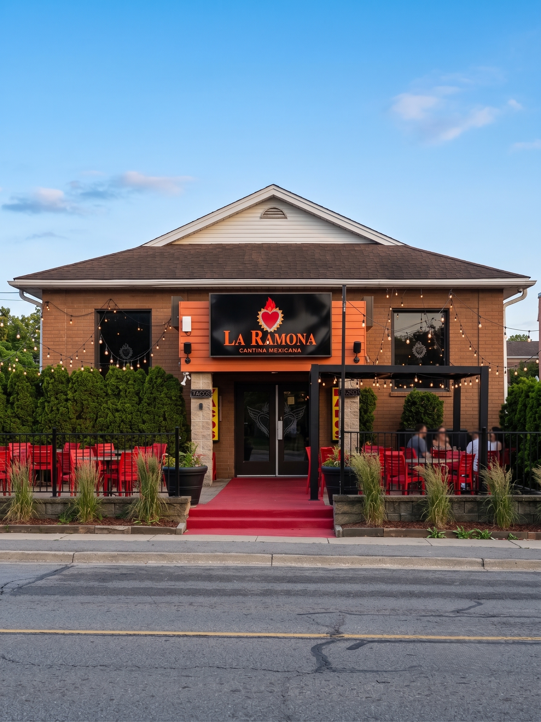 Exterior of an authentic Mexican restaurant called La Ramona with outdoor seating, red chairs, string lights, and a red carpeted entrance, under a blue sky.