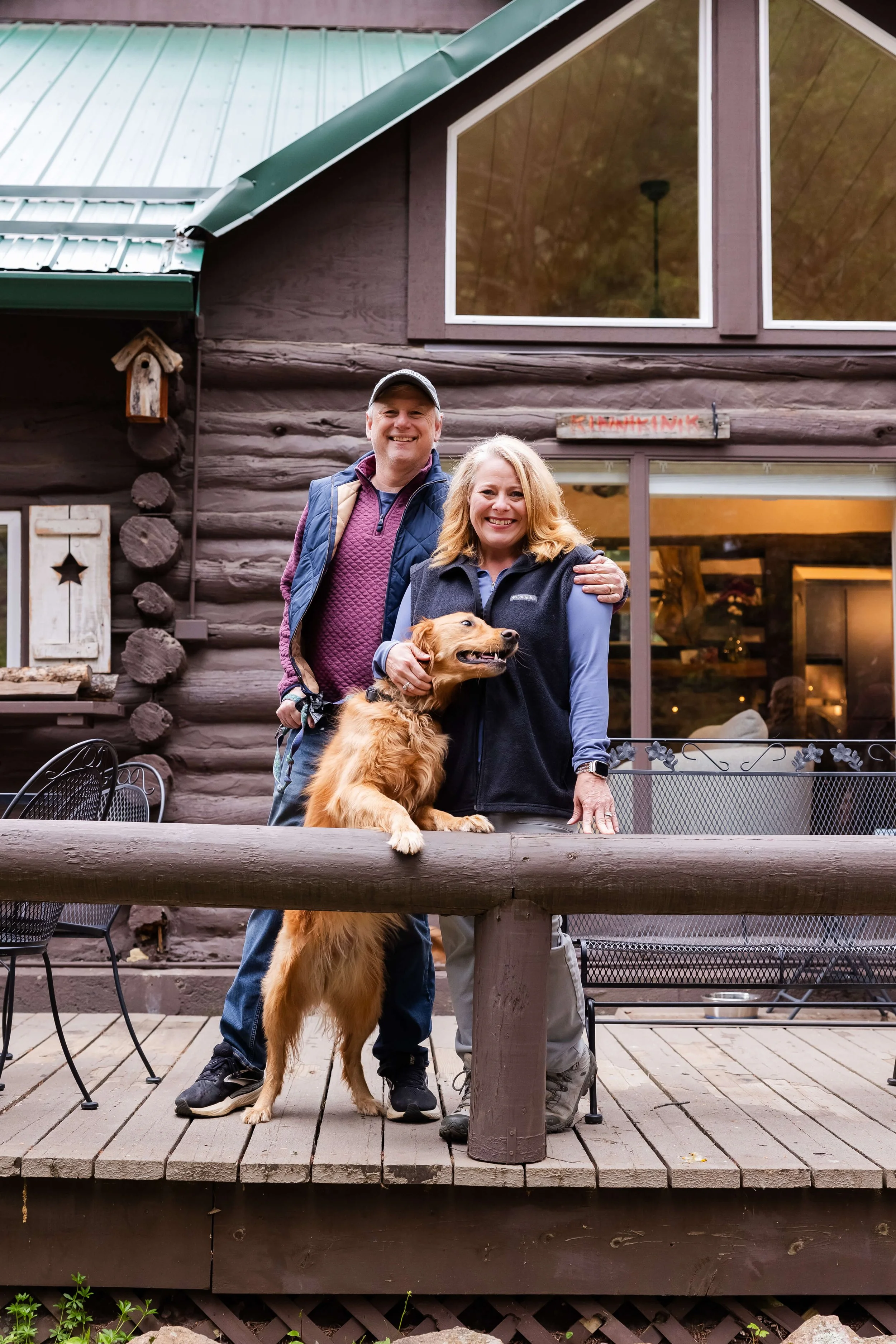 Mountain cabin for wellness retreat with two people and a dog, standing outside.