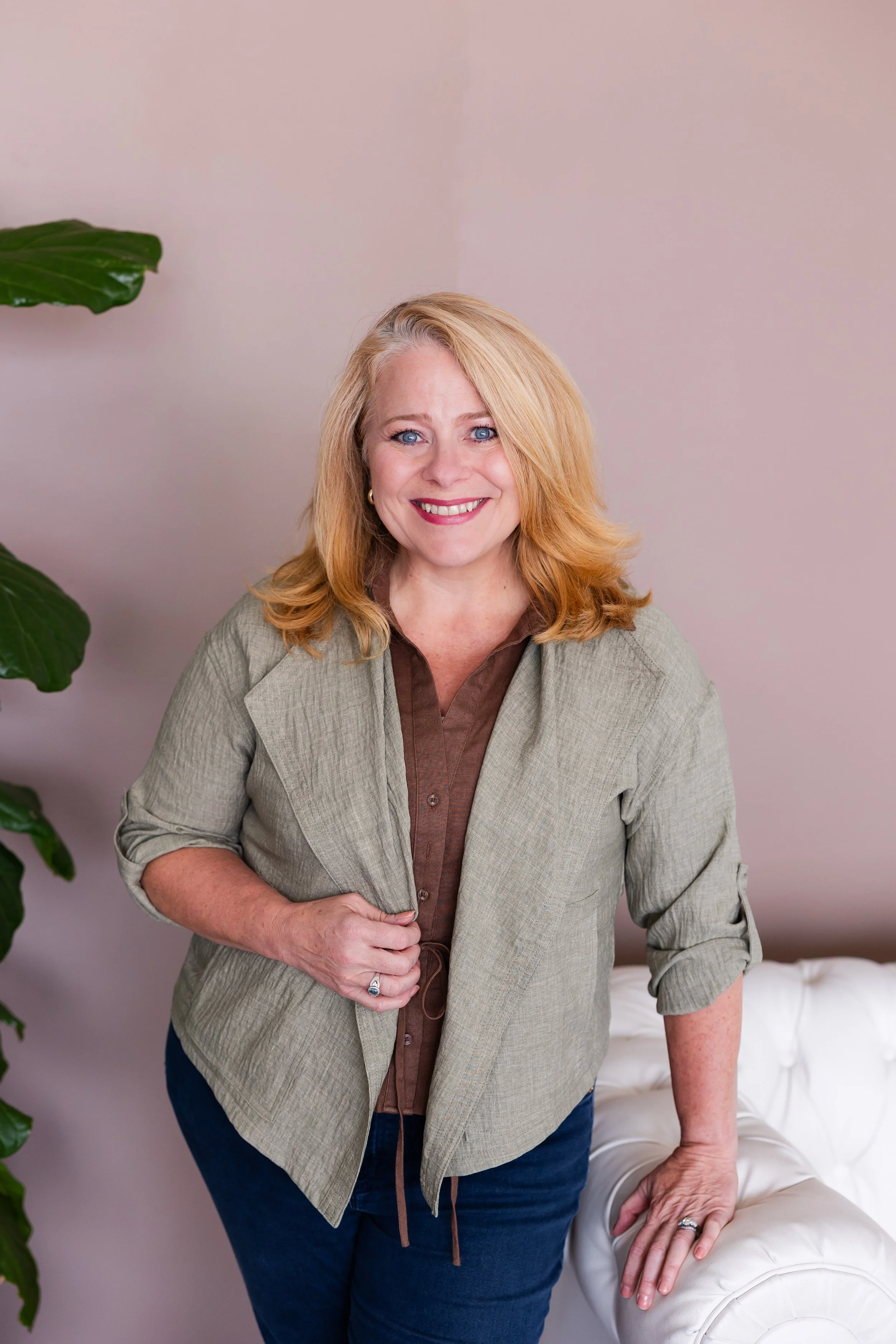 Founder and wellness coach Lisa Summers standing next to a white sofa