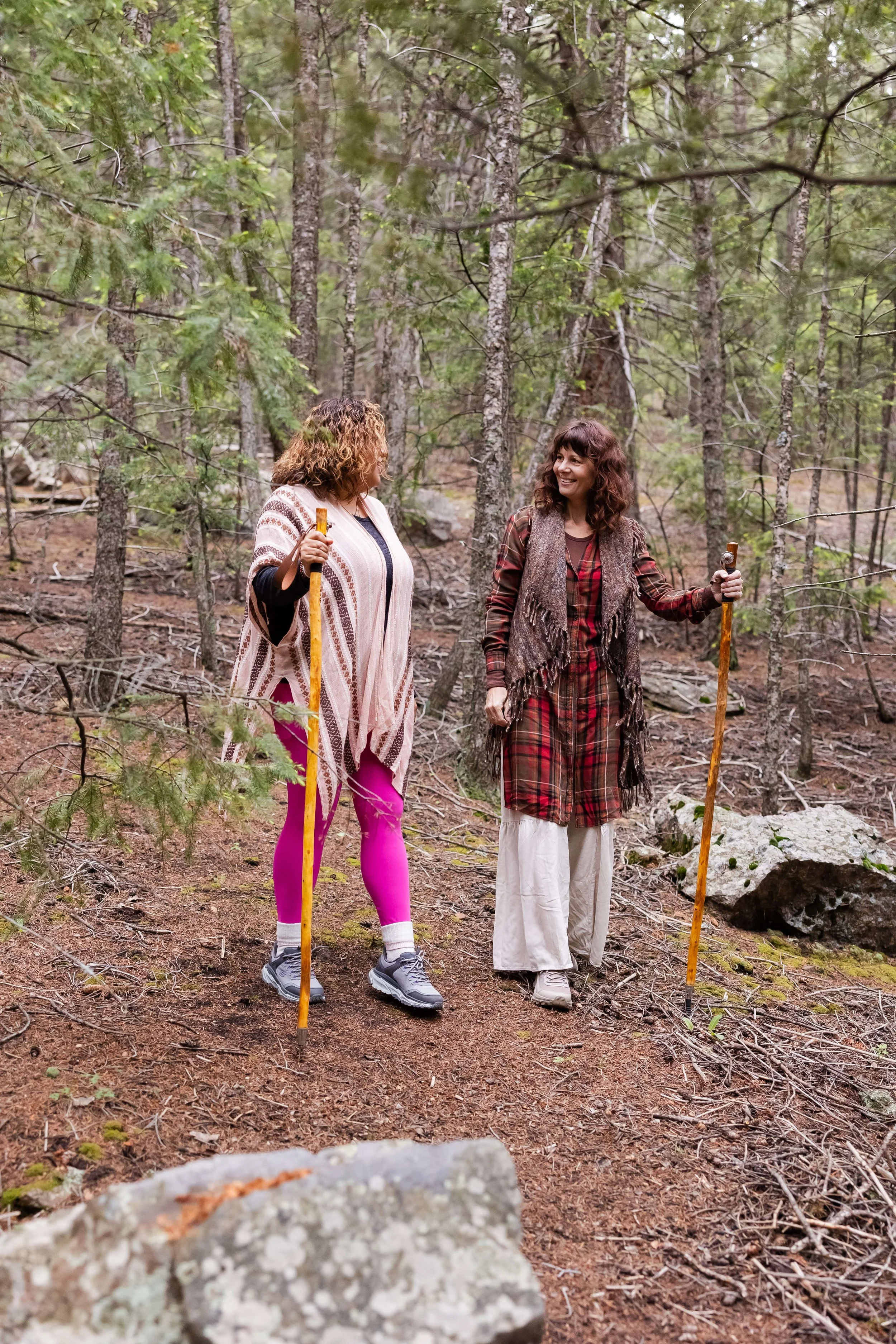 Two women hiking in a wooded forest, on leadership training