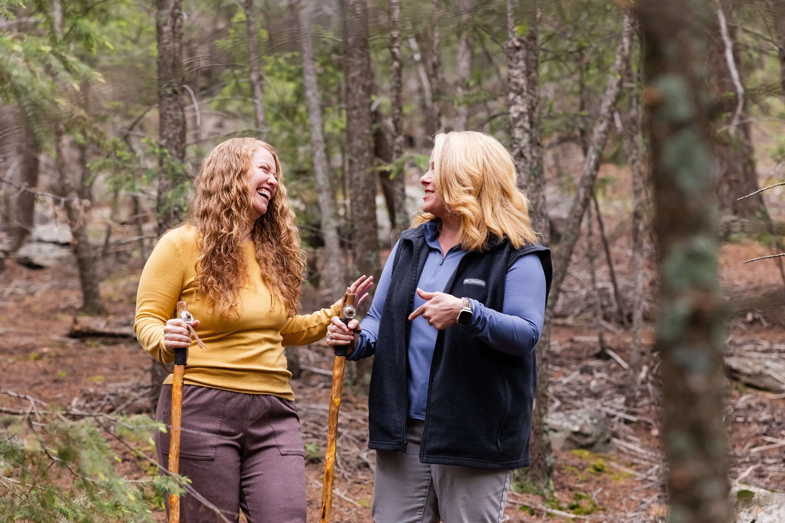 Two women with long, curly red hair talking and laughing in Colorado, on a small group leadership training. 