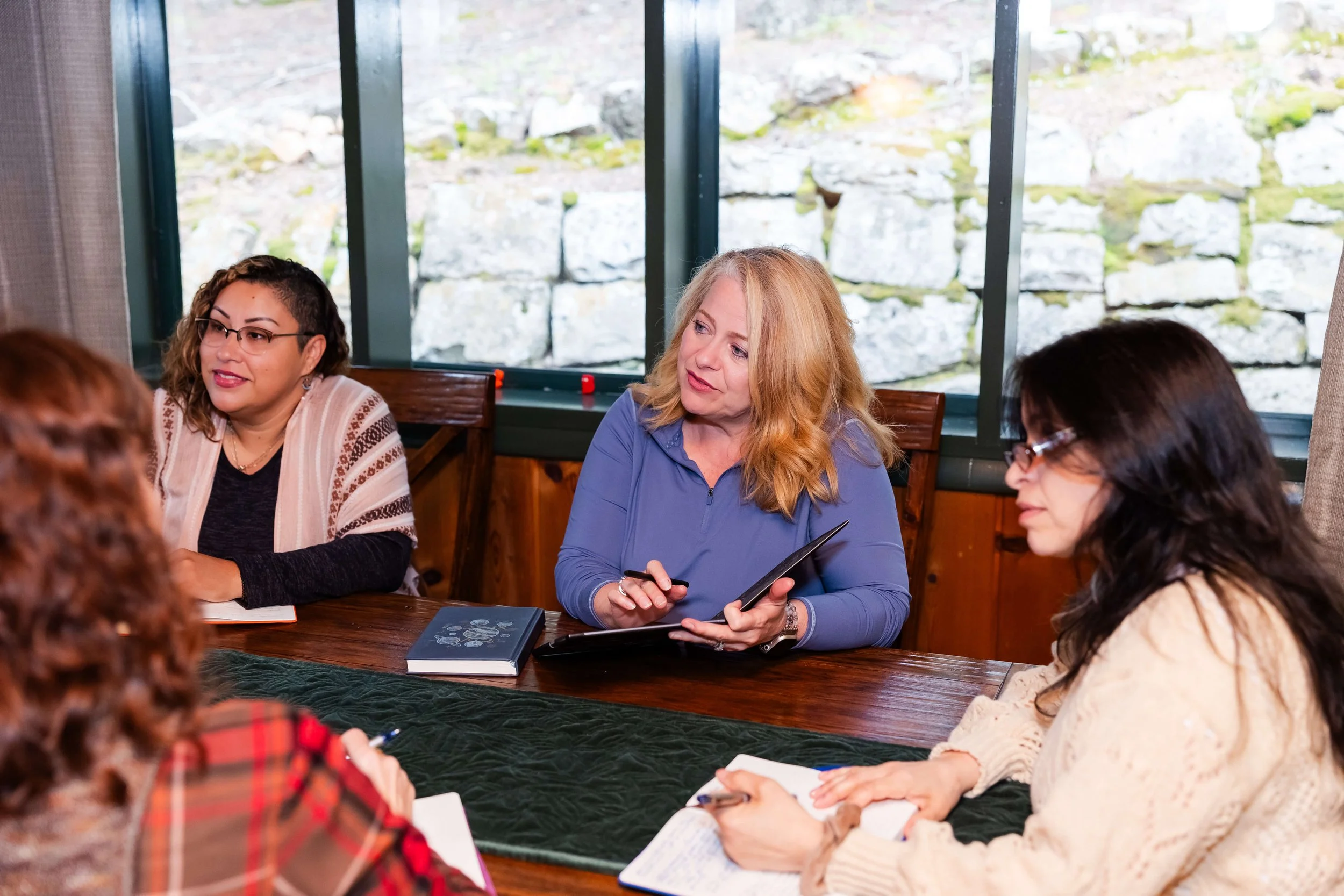 Women seated around a wooden table during a business leadership session