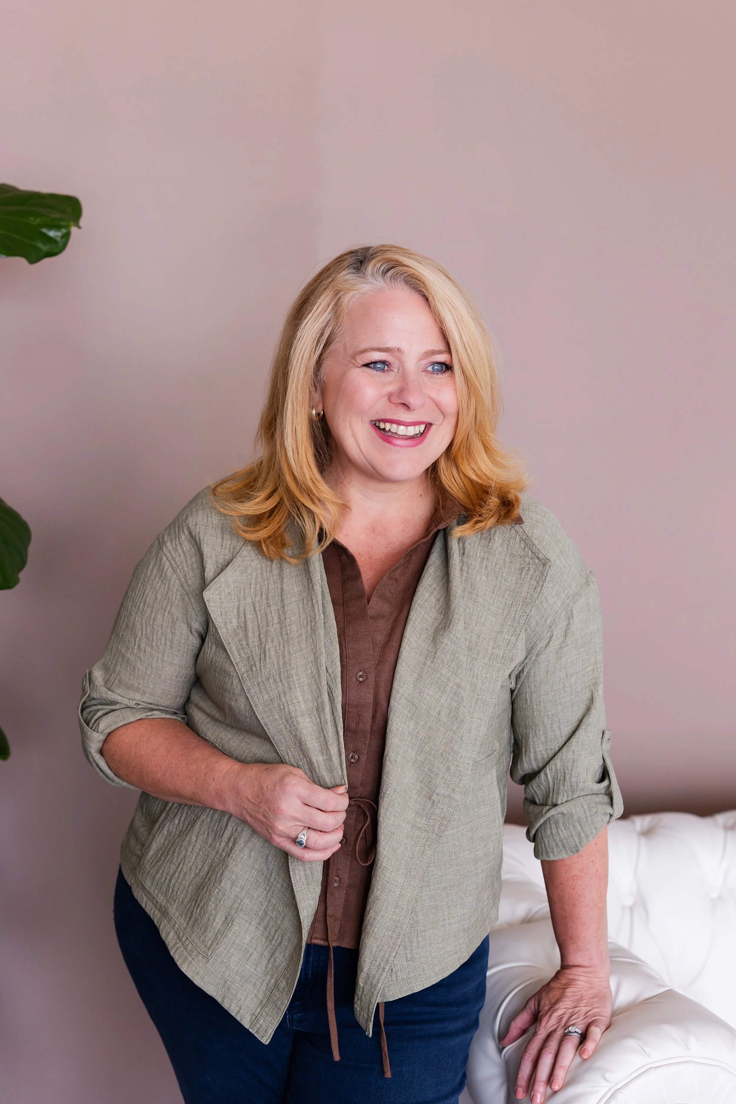 Founder and wellness coach Lisa Summers standing next to a white sofa