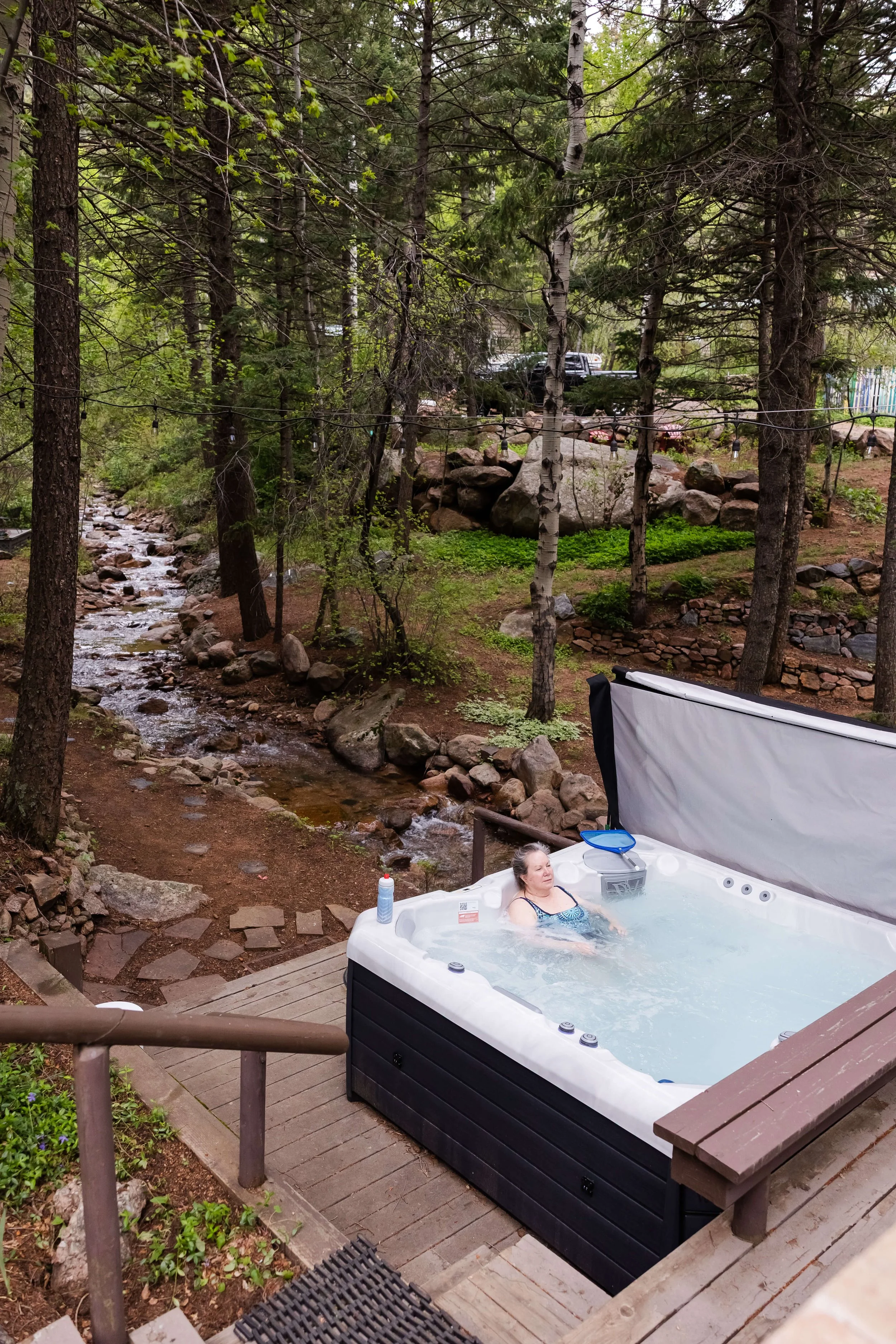 A woman relaxing in a hot tub outdoors at a mountain retreat