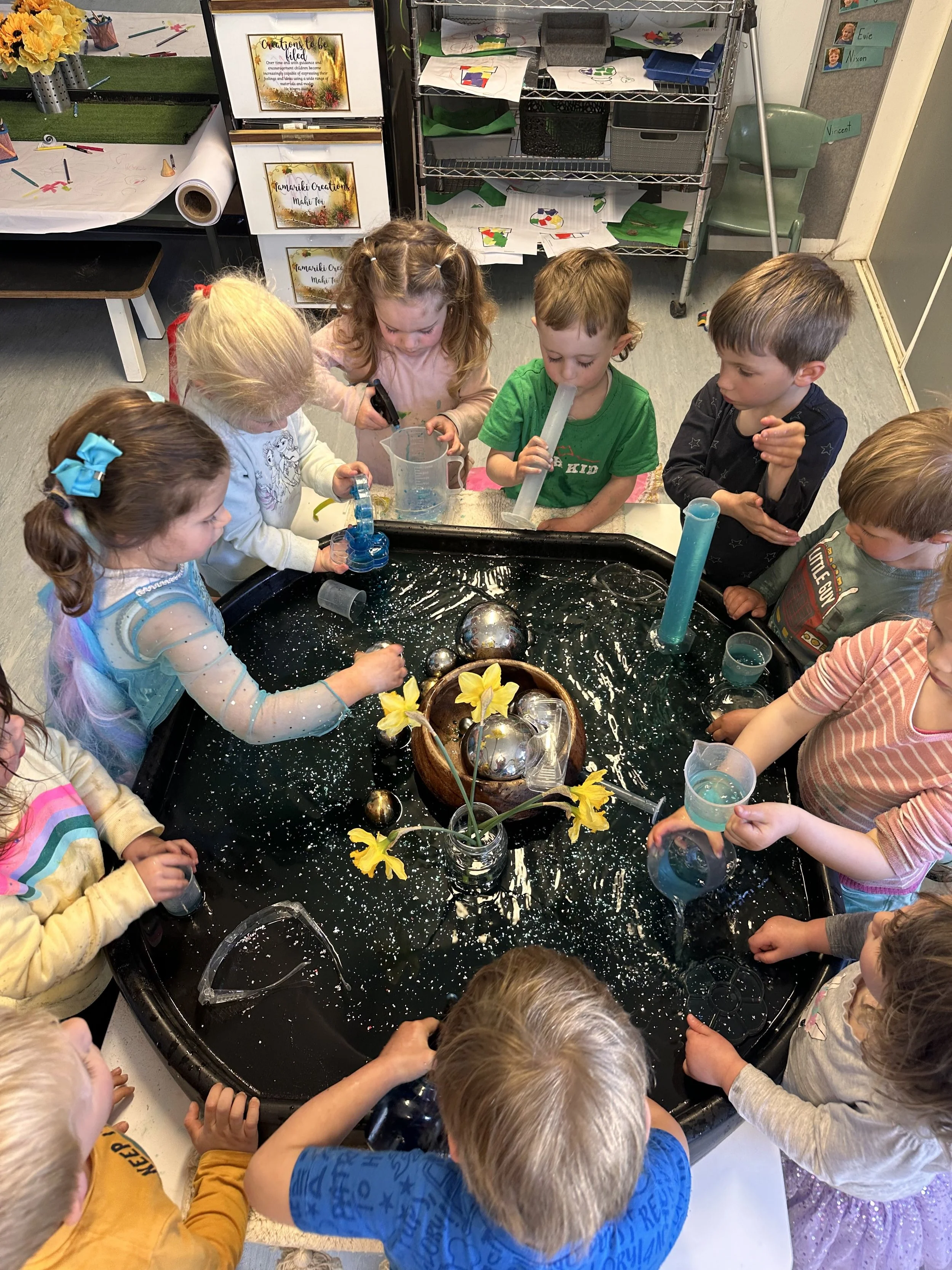 Group of young children gathered playing with water at Country Wonders Early Learning Centre