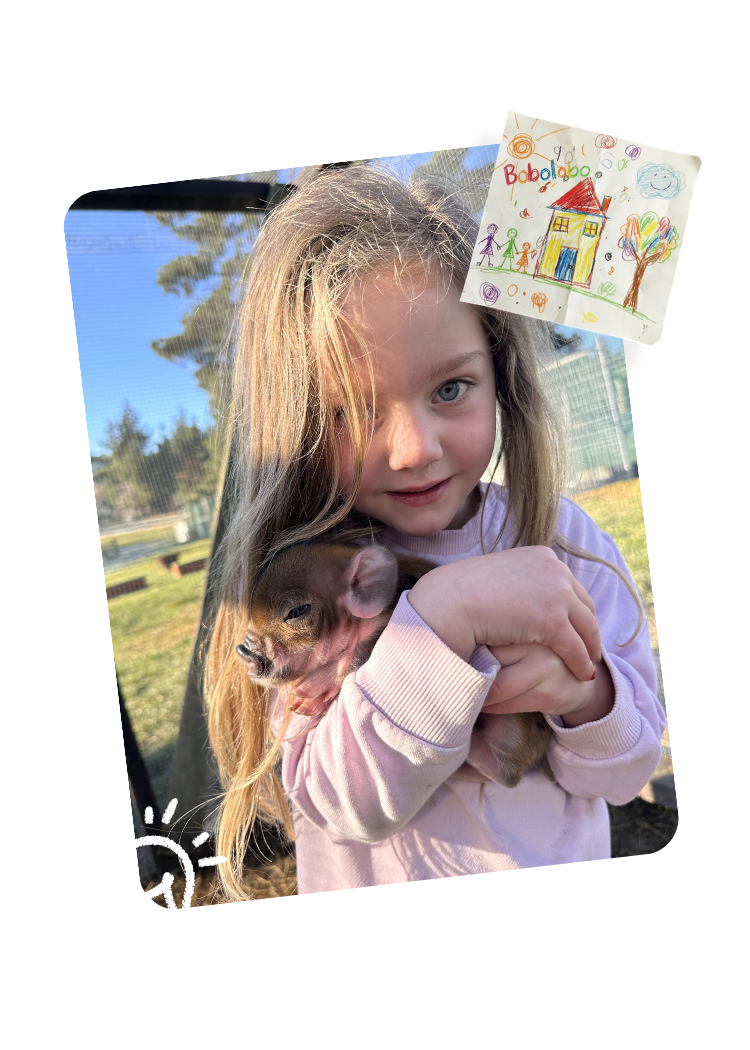 Young girl holding a rabbit outdoors at Country Wonders childcare centre in Loburn, North Canterbury