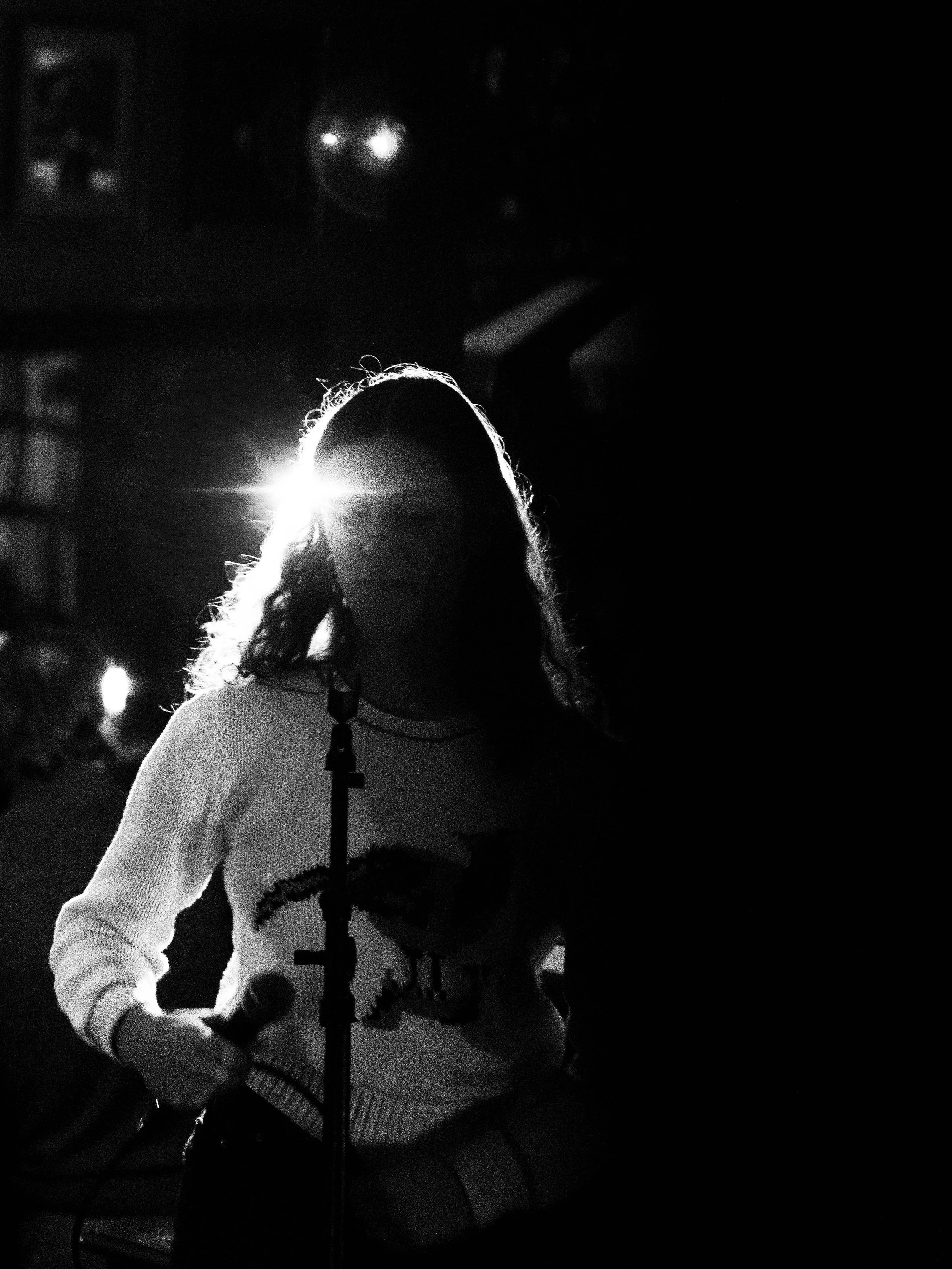 Essie standing in black and white with a light behind her.