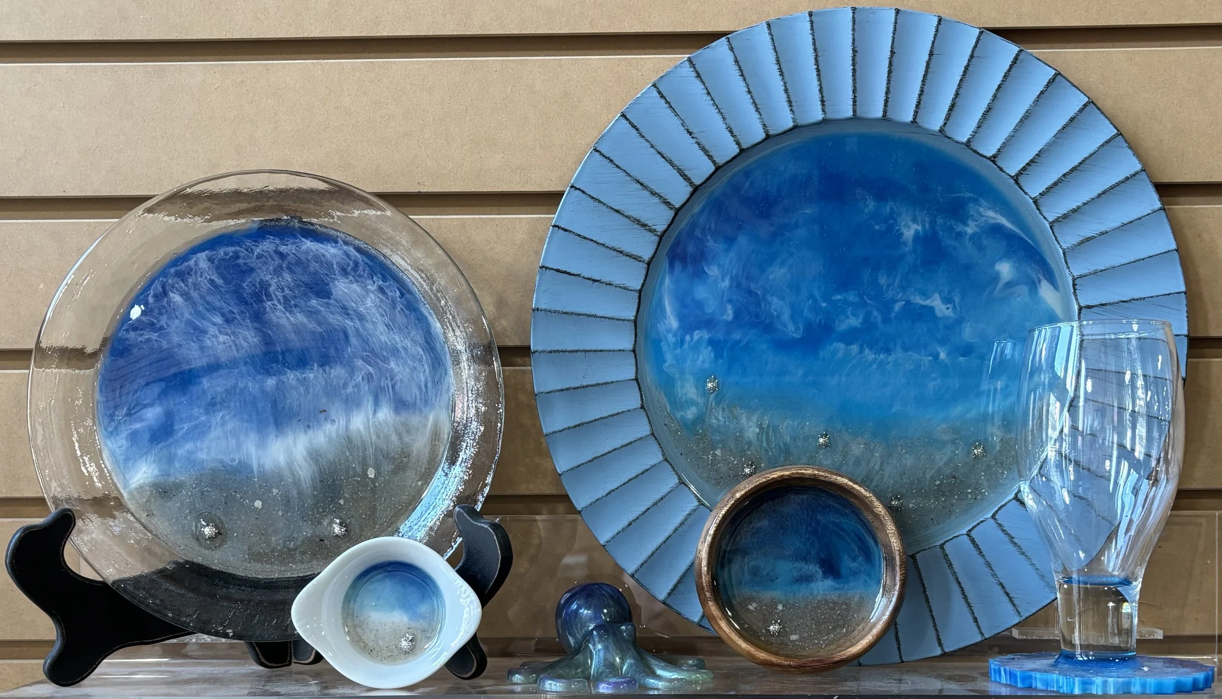 Various glassware and ceramic dishware with epoxy seascape design.
