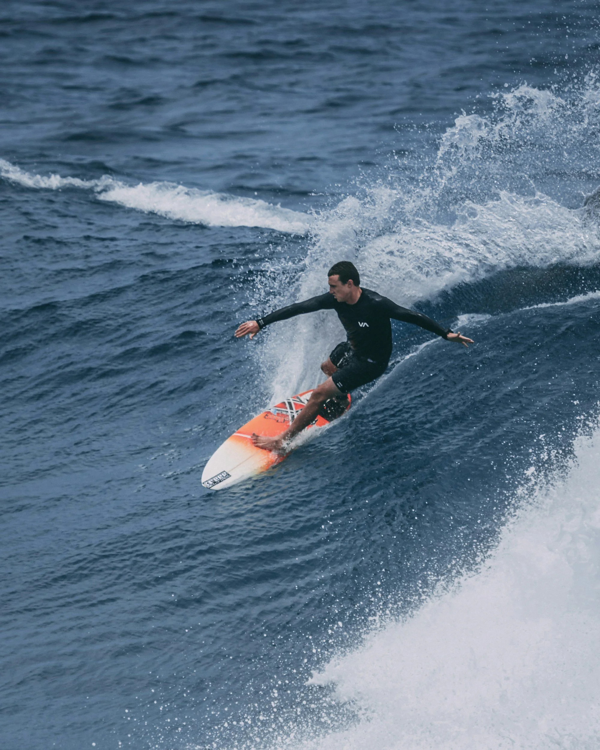 A person surfing on a wave in the ocean during daytime.