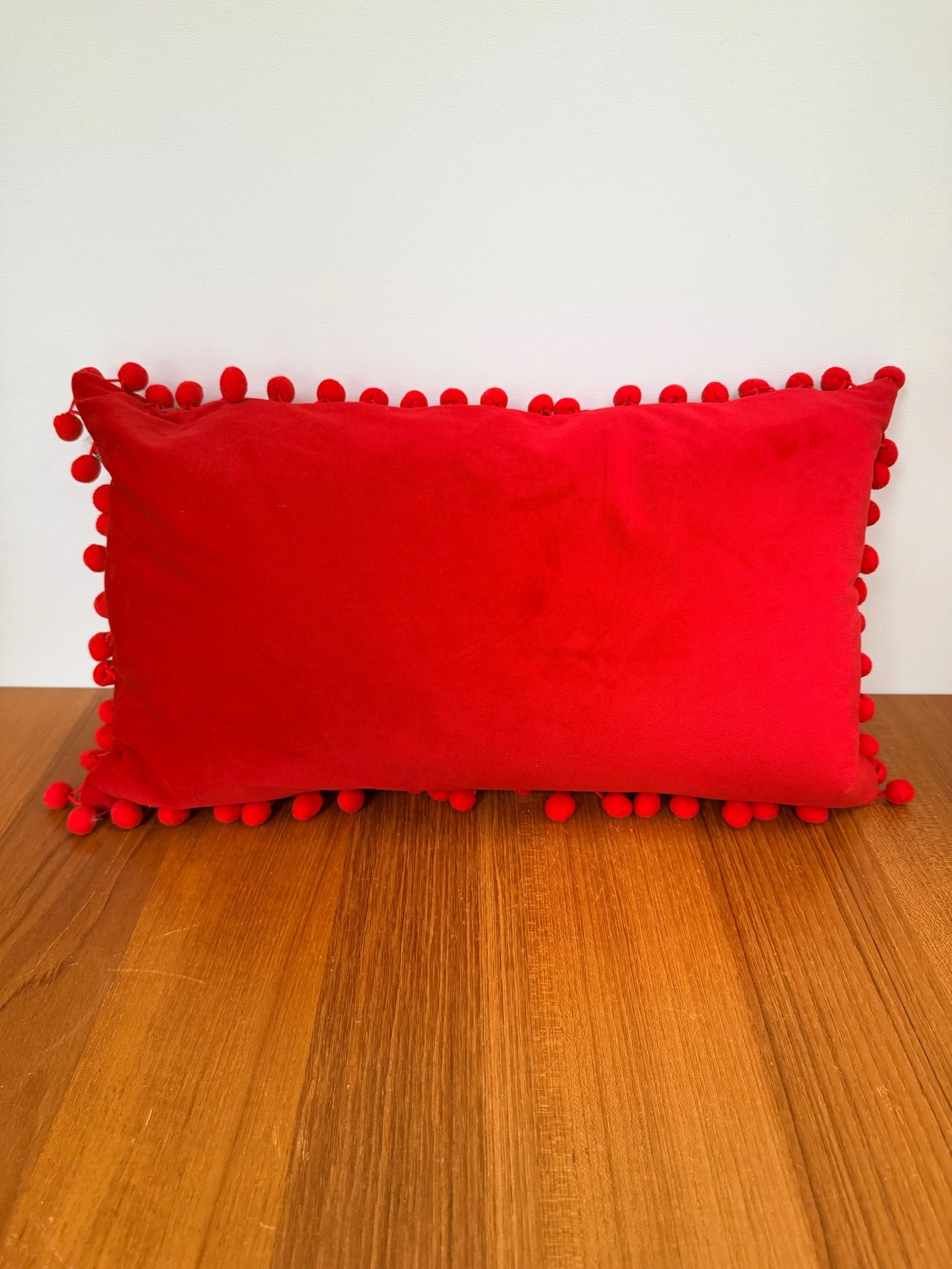 red velvet long pillow with balls