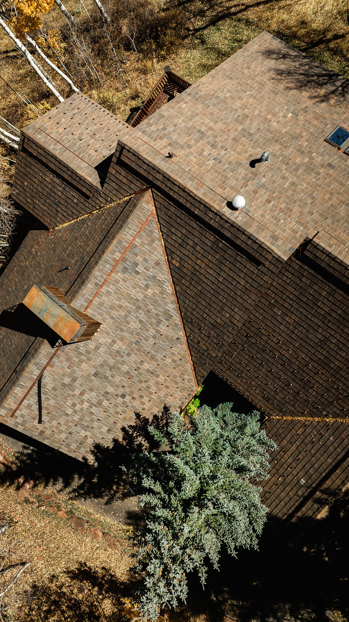 Aerial view of Brava synthetic shake roof in mixed brown and rust tones on a complex multi-pitch residential home, premium roofing Idaho