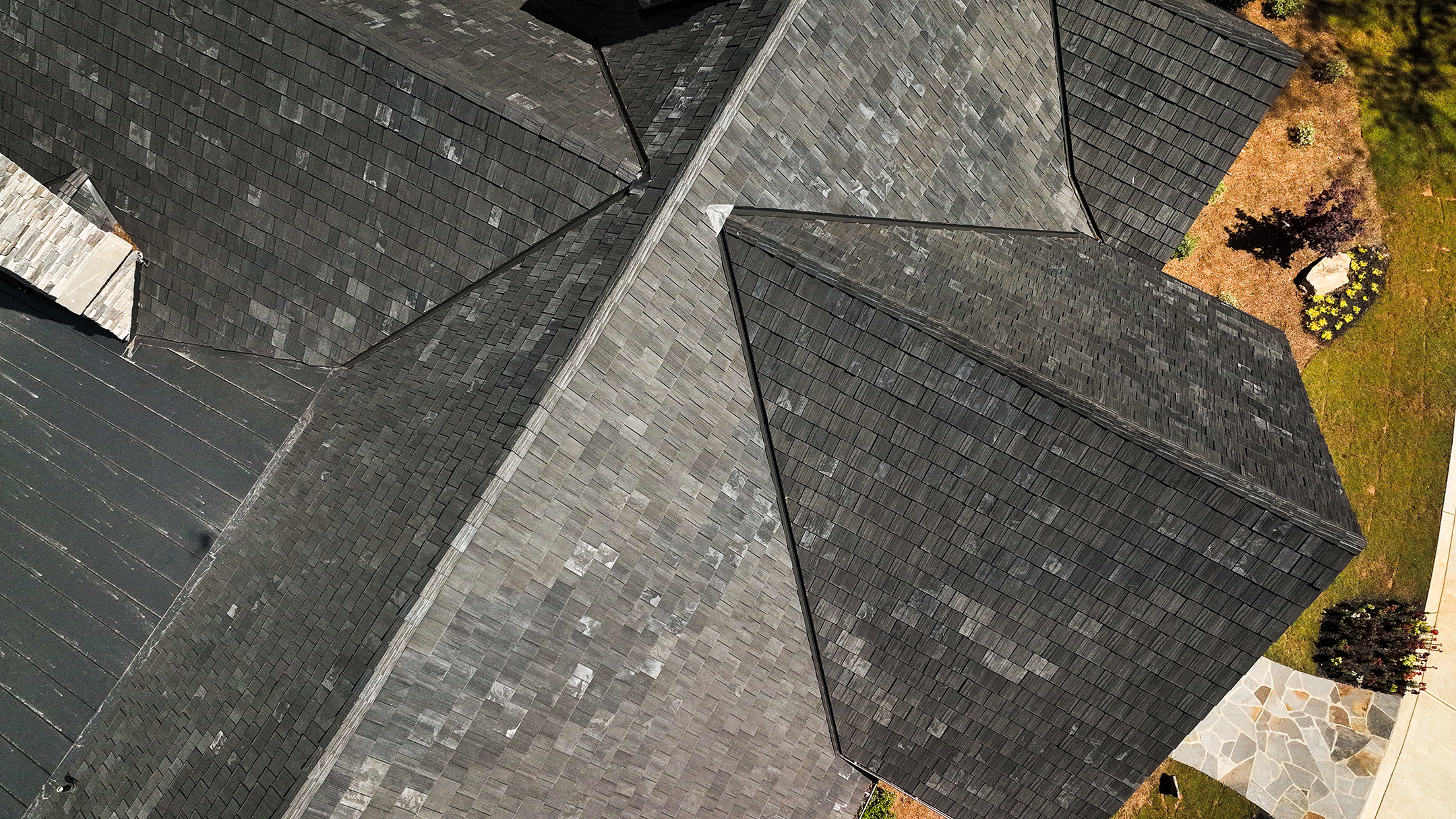 Aerial view of Brava synthetic slate roofing in dark charcoal on a complex multi-pitch roofline, specialty roofing contractor Idaho