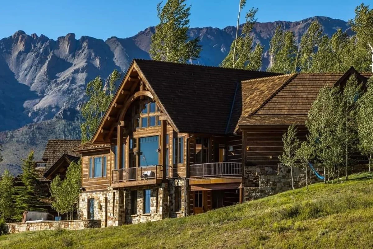 CeDUR synthetic shake roofing on a luxury log and stone mountain home with dramatic Rocky Mountain backdrop, premium roofing Idaho Mountain West