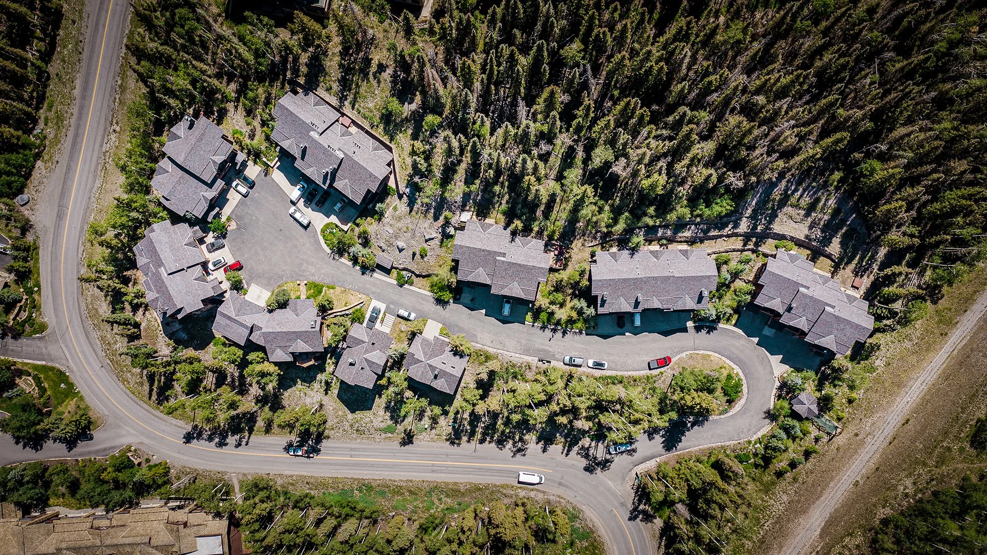 Aerial view of Brava synthetic shake roofing across a mountain resort community nestled in alpine forest, commercial and resort roofing Idaho