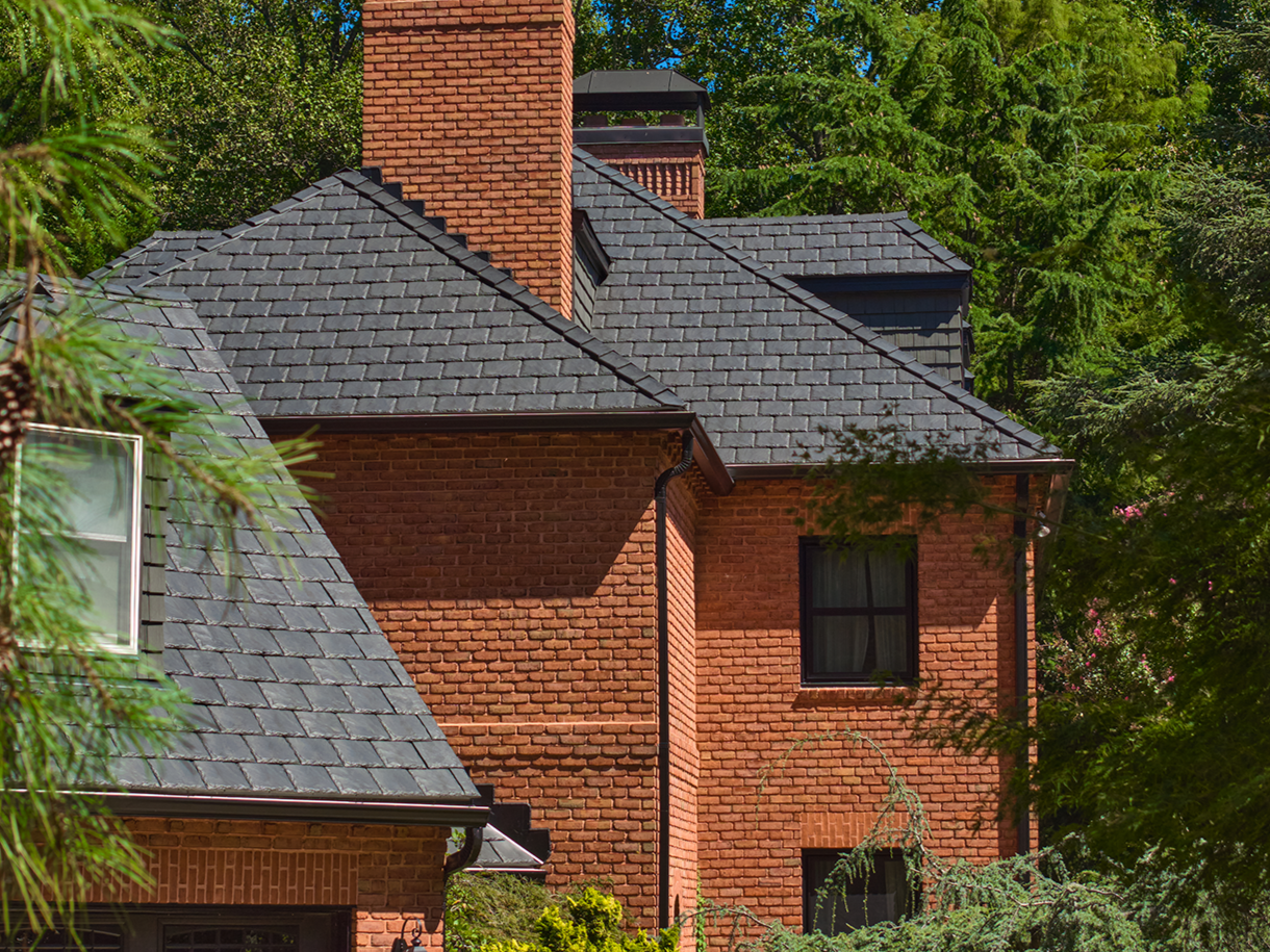 Brava synthetic slate roofing in charcoal installed on a classic brick estate home with brick chimney, luxury residential roofing Mountain West