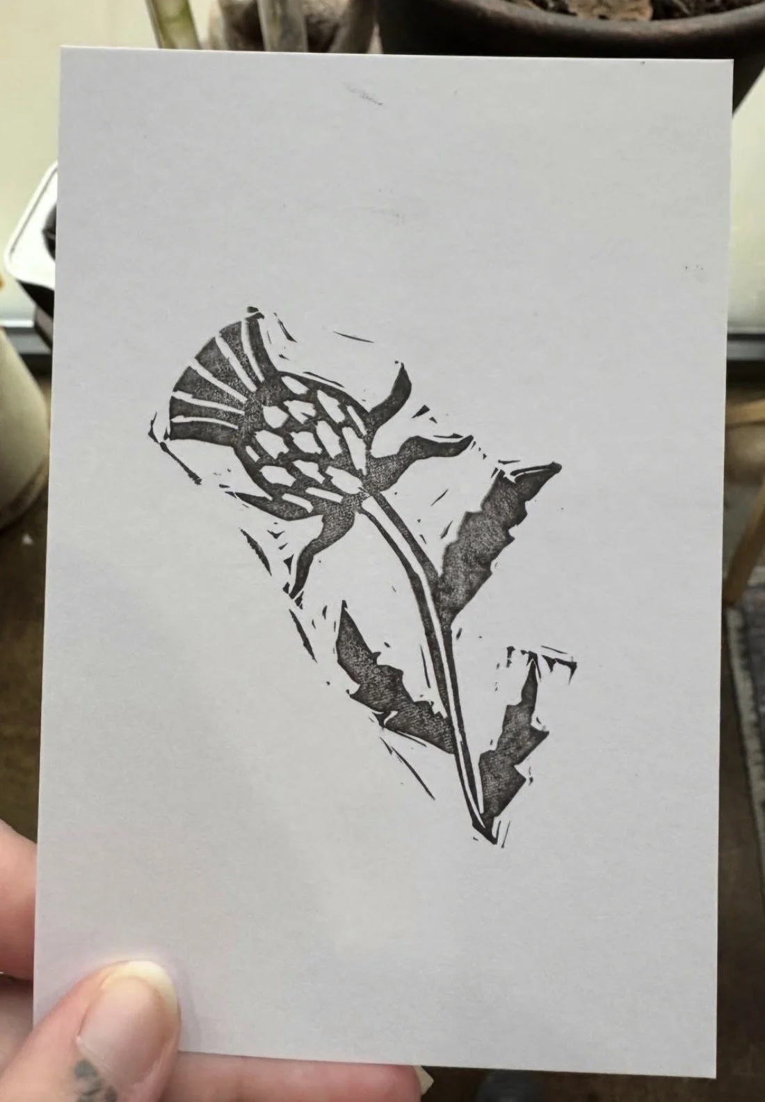 A piece of paper with a black stencil of a butterfly and a leaf on it.