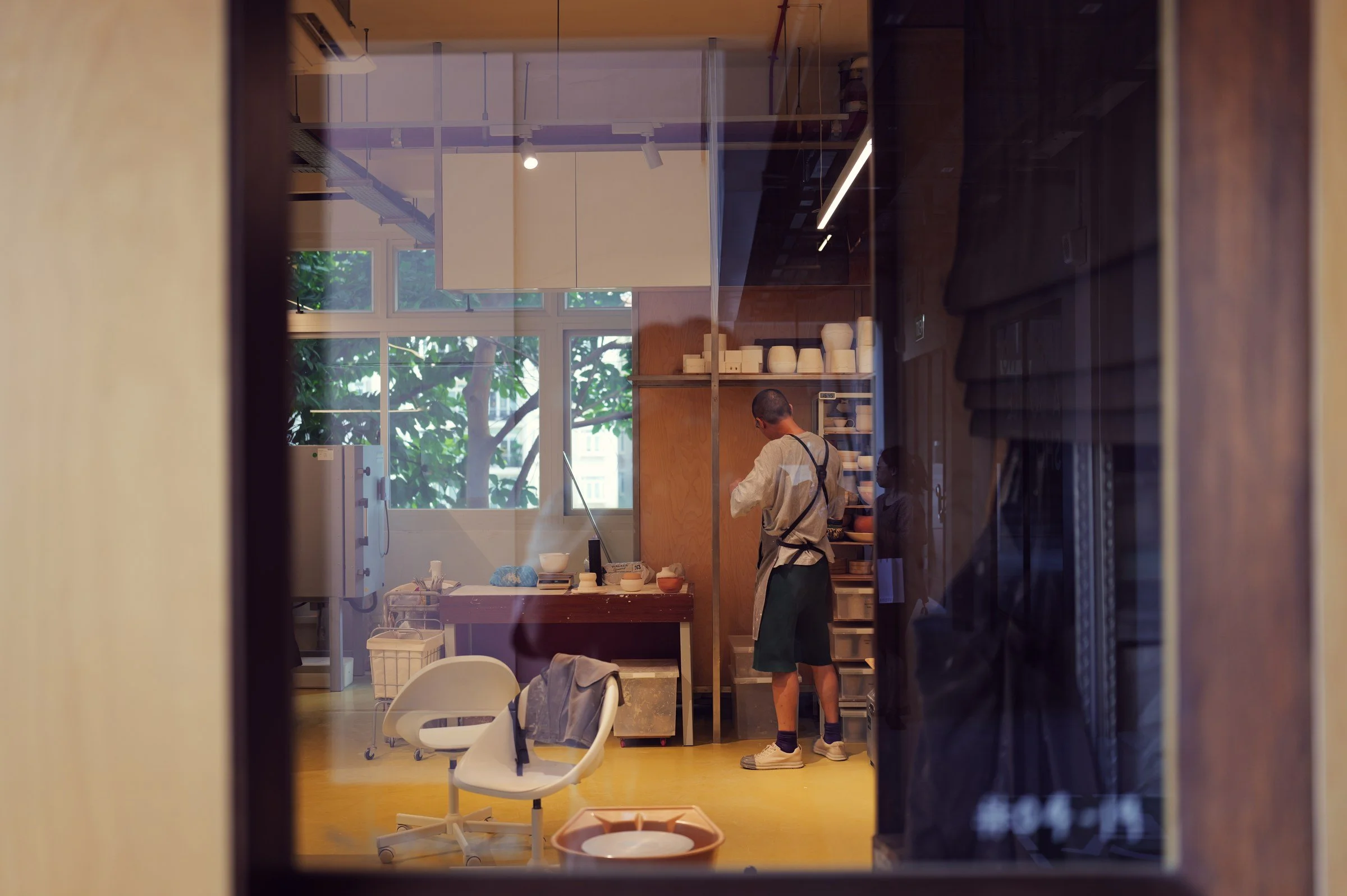 Furniture and warm wooden interiors seen through a shop window at New Bahru.