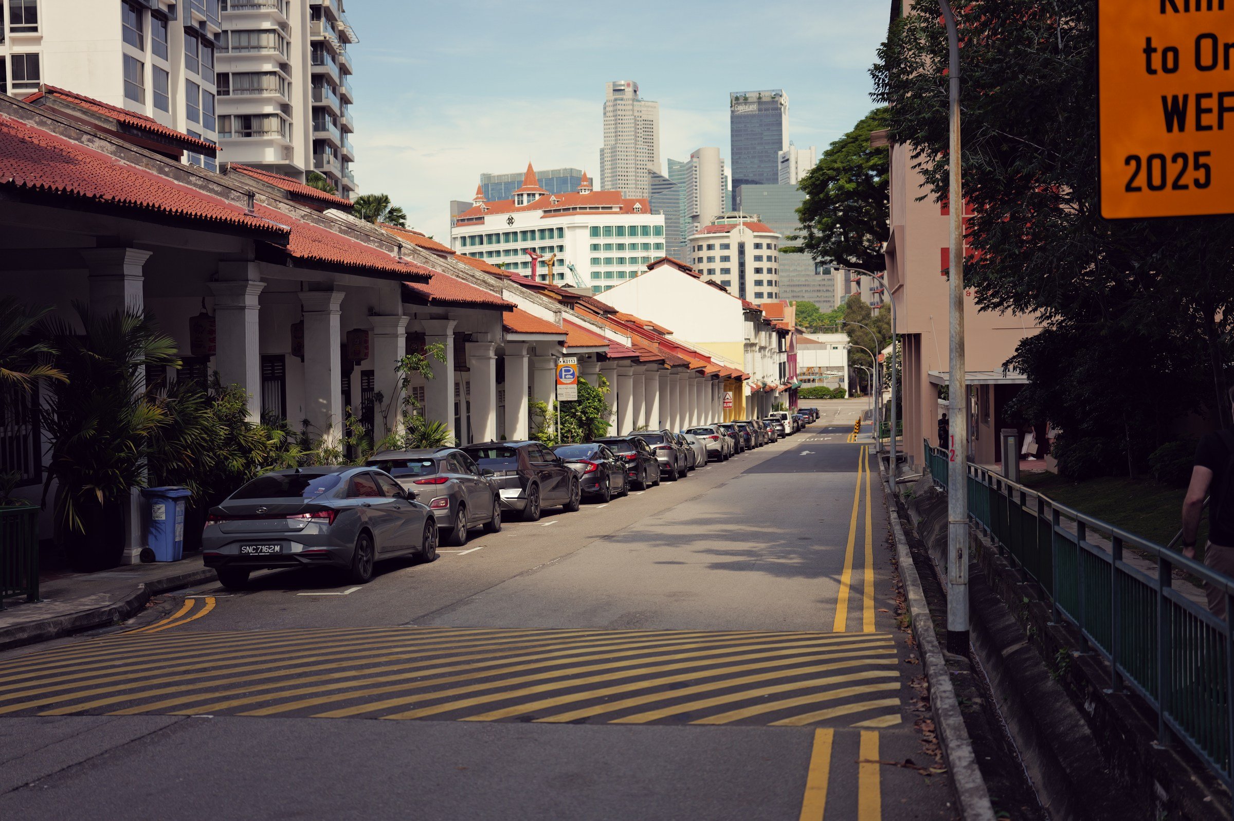 Low-rise buildings and parked cars along Kim Yam Road near New Bahru.