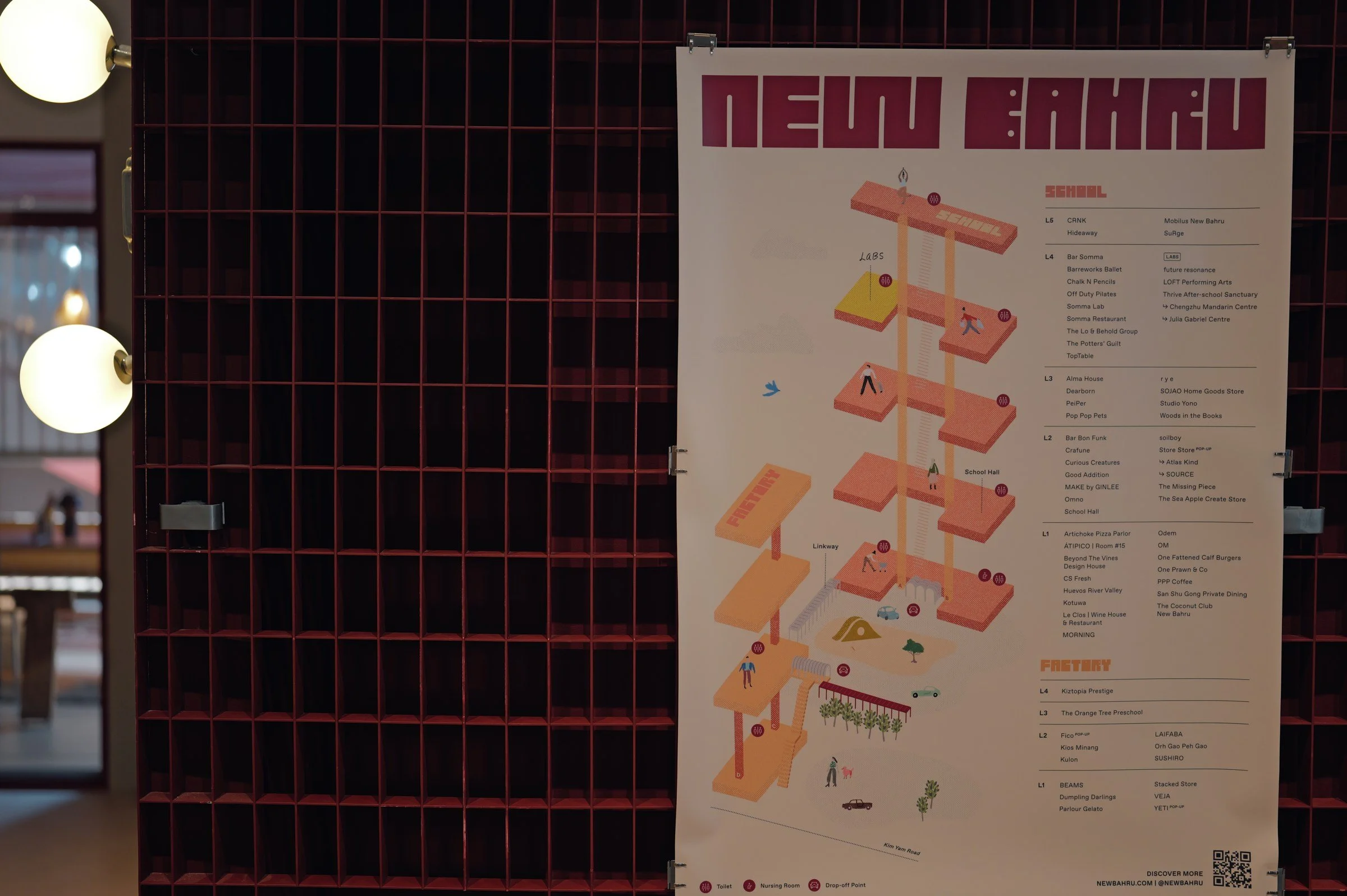 New Bahru building directory mounted beside red metal grilles.