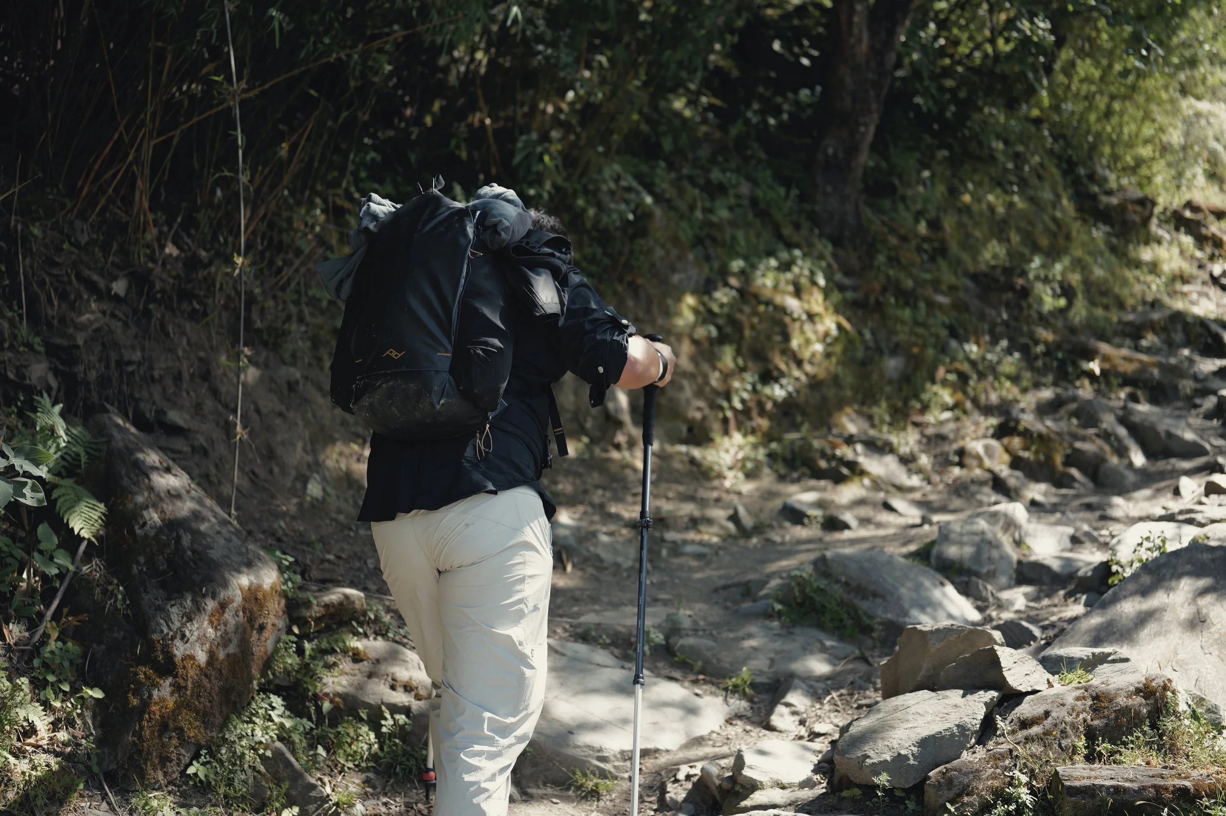 Hiker climbing a rocky trail in Tiger Leaping Gorge — Leica Q3 43 travel photography