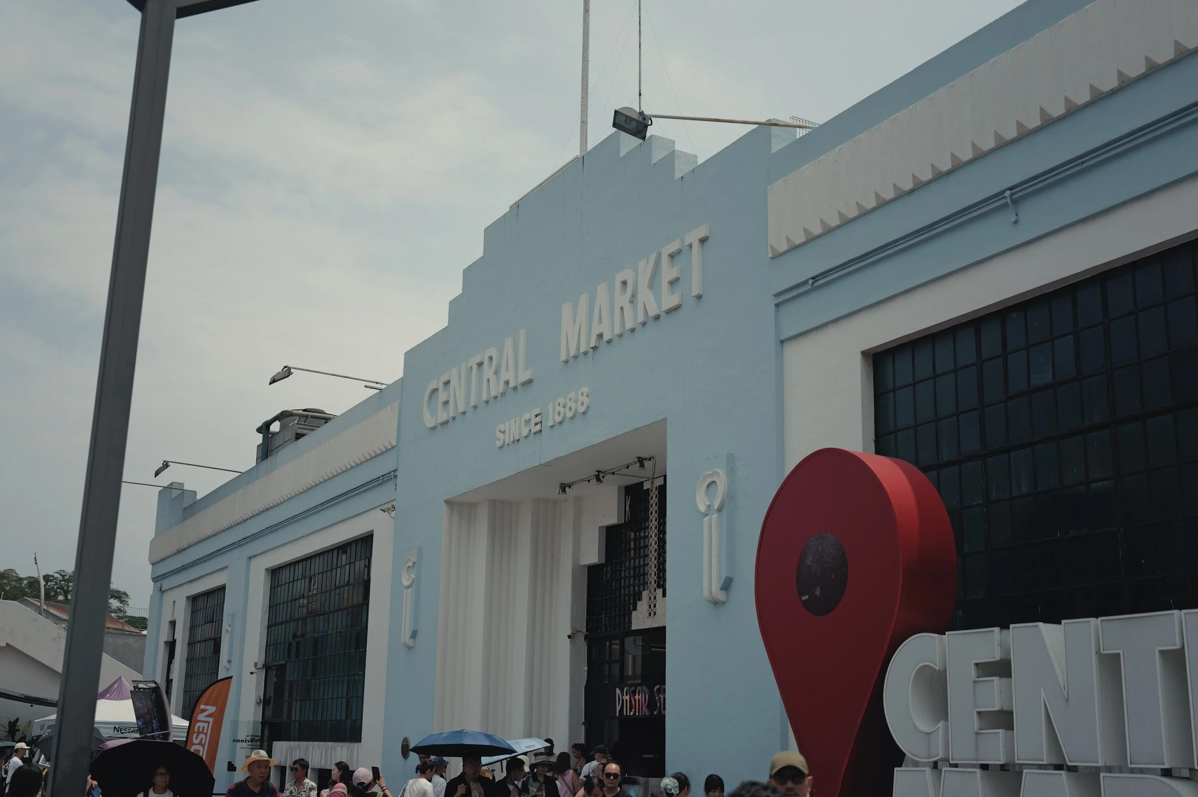 The pale blue Central Market facade rises above a busy street.