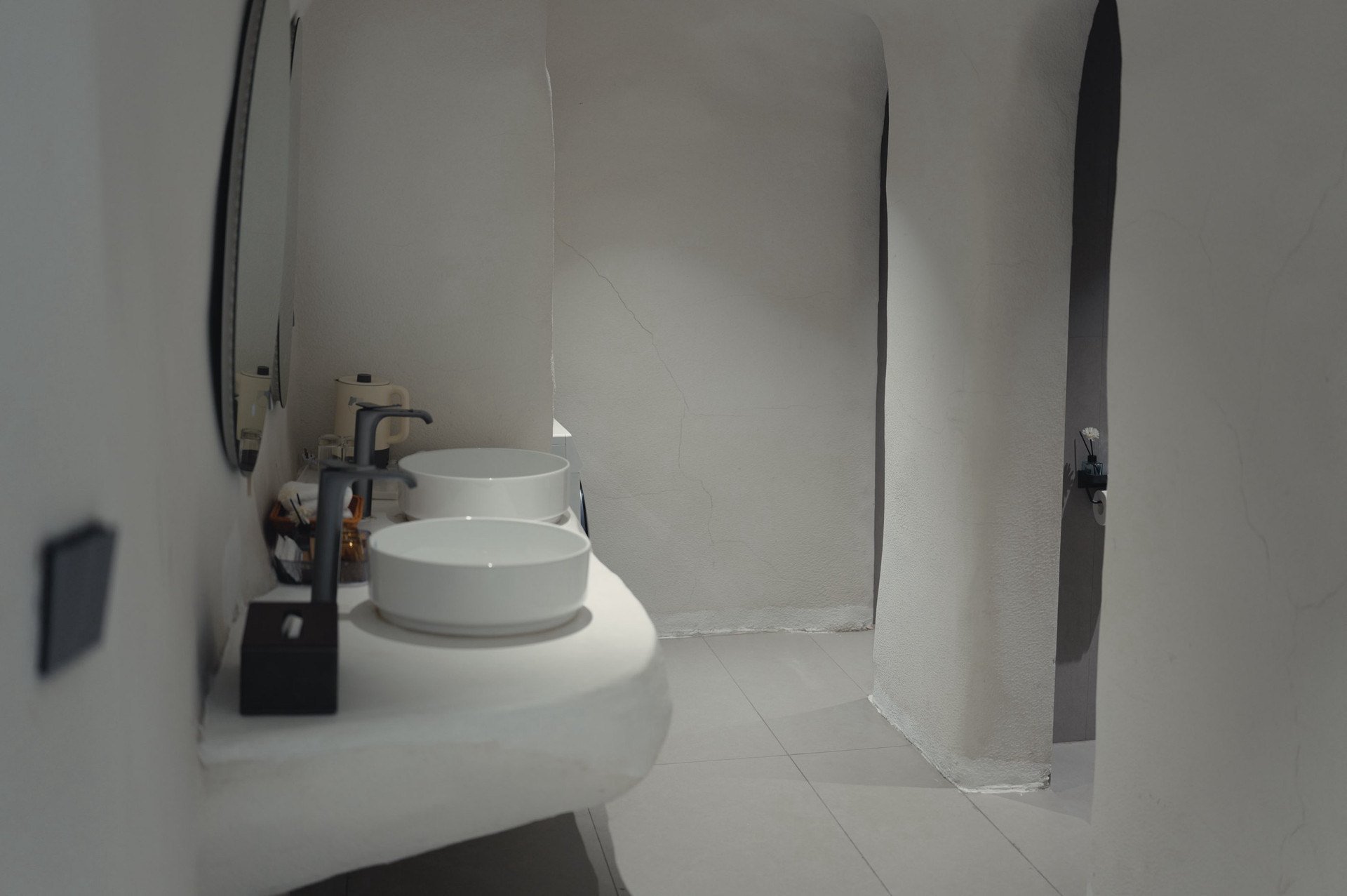 Sculpted white washbasin and curved cave-style bathroom walls at Qinglan Cave Style Hotel in Dali.