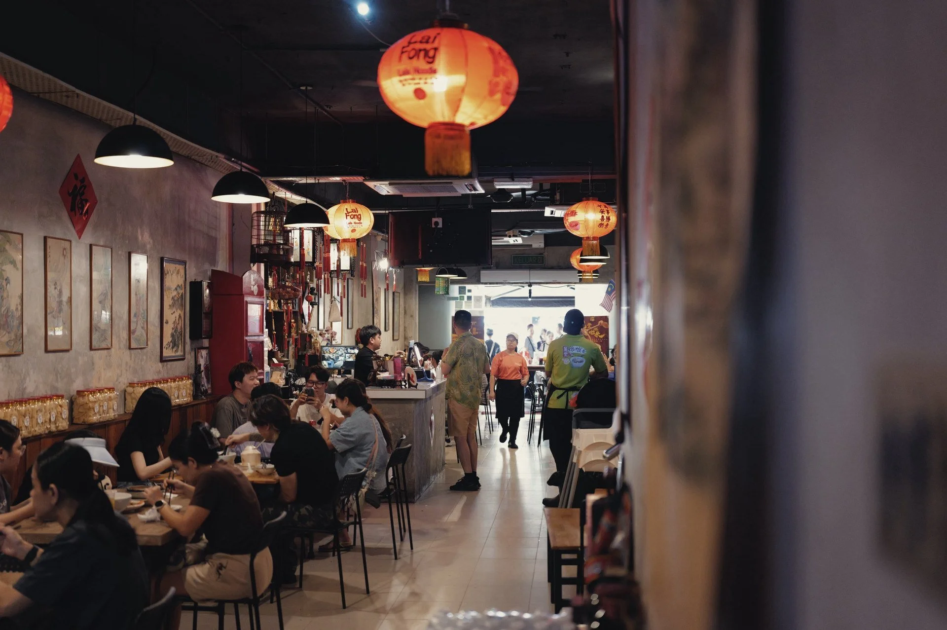 Diners seated beneath red lanterns inside Lai Foong Lala Noodles in Kuala Lumpur’s Chinatown.