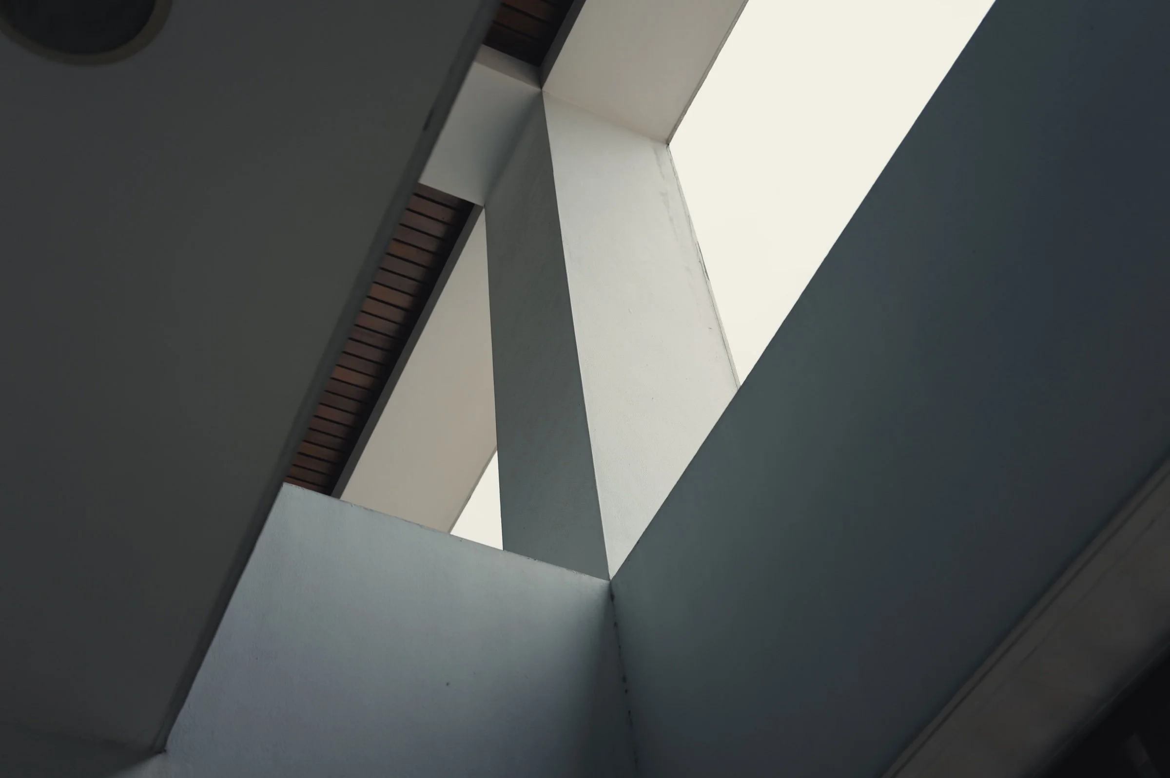 Angular white walls meet in a geometric pattern of light and shadow.