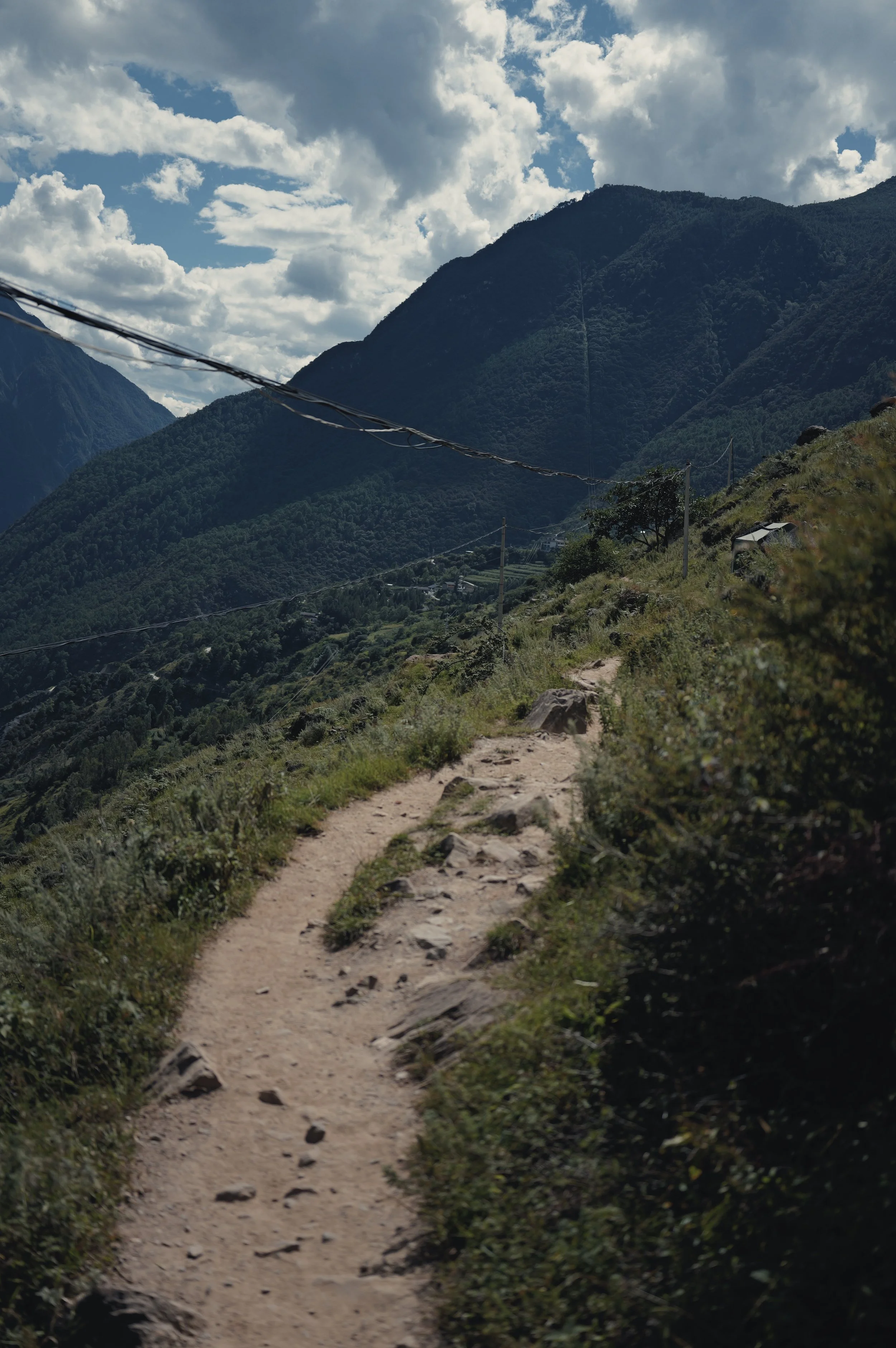 Rocky hiking trail beneath blue sky in Tiger Leaping Gorge, photographed with a Leica Q3 43