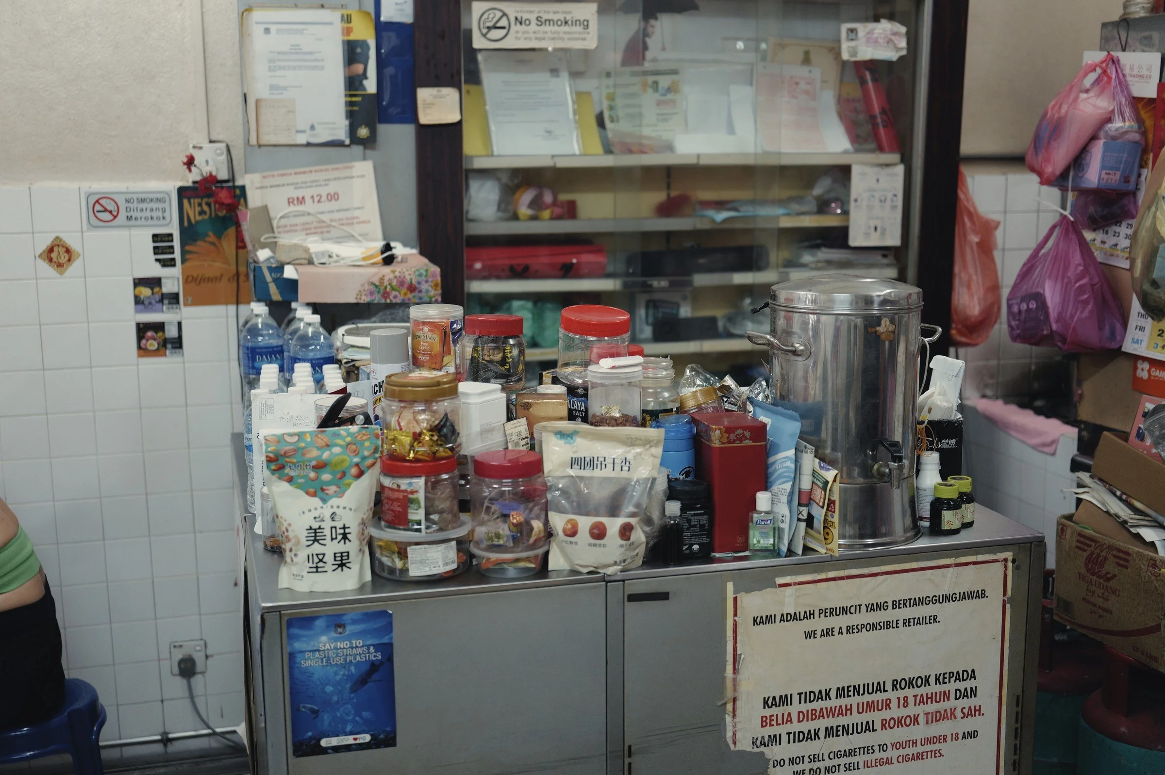 Jars, tins and drink-making utensils crowd a small shop counter.