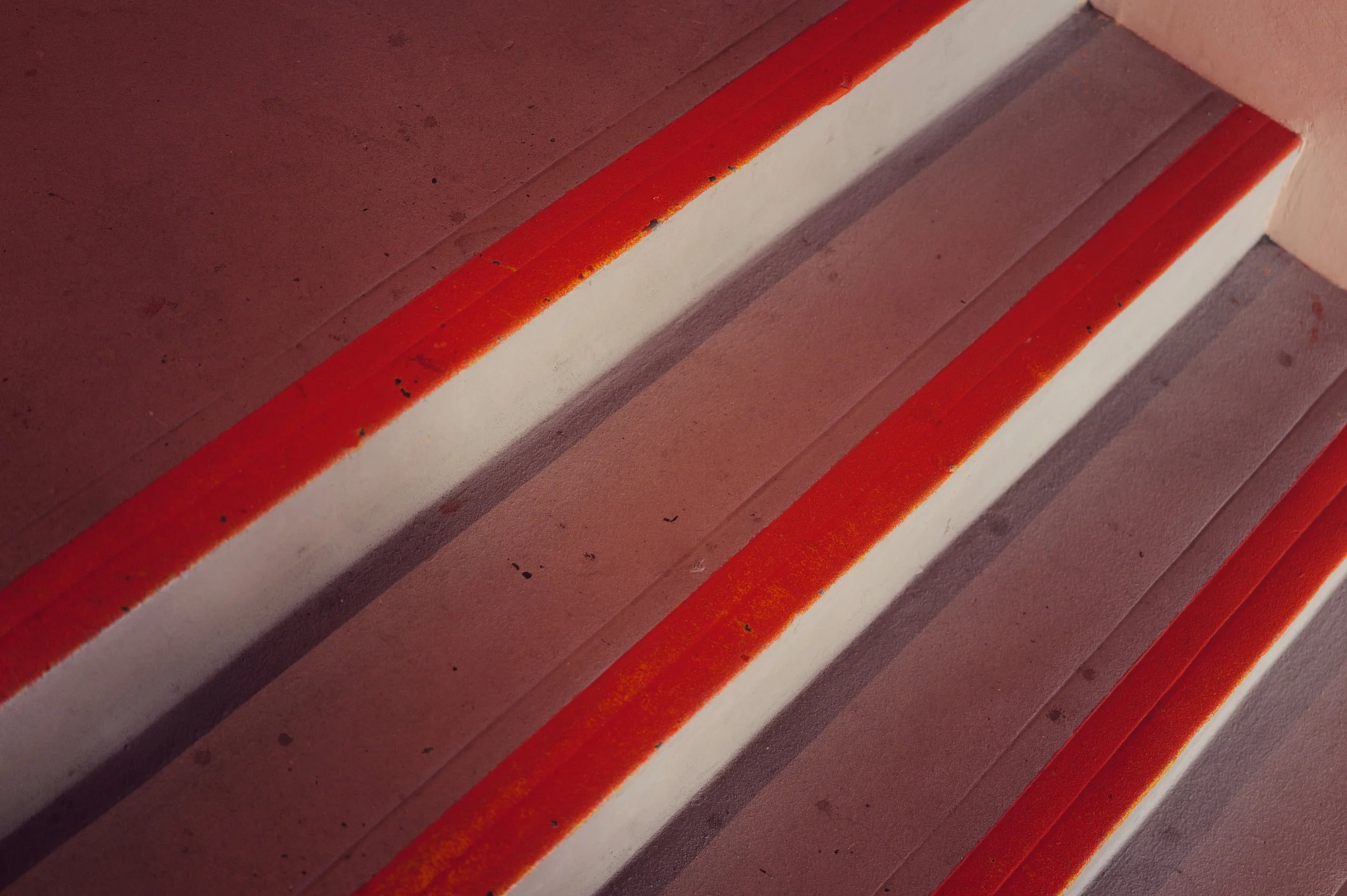 Close-up of staircase steps with orange safety strips on edges.
