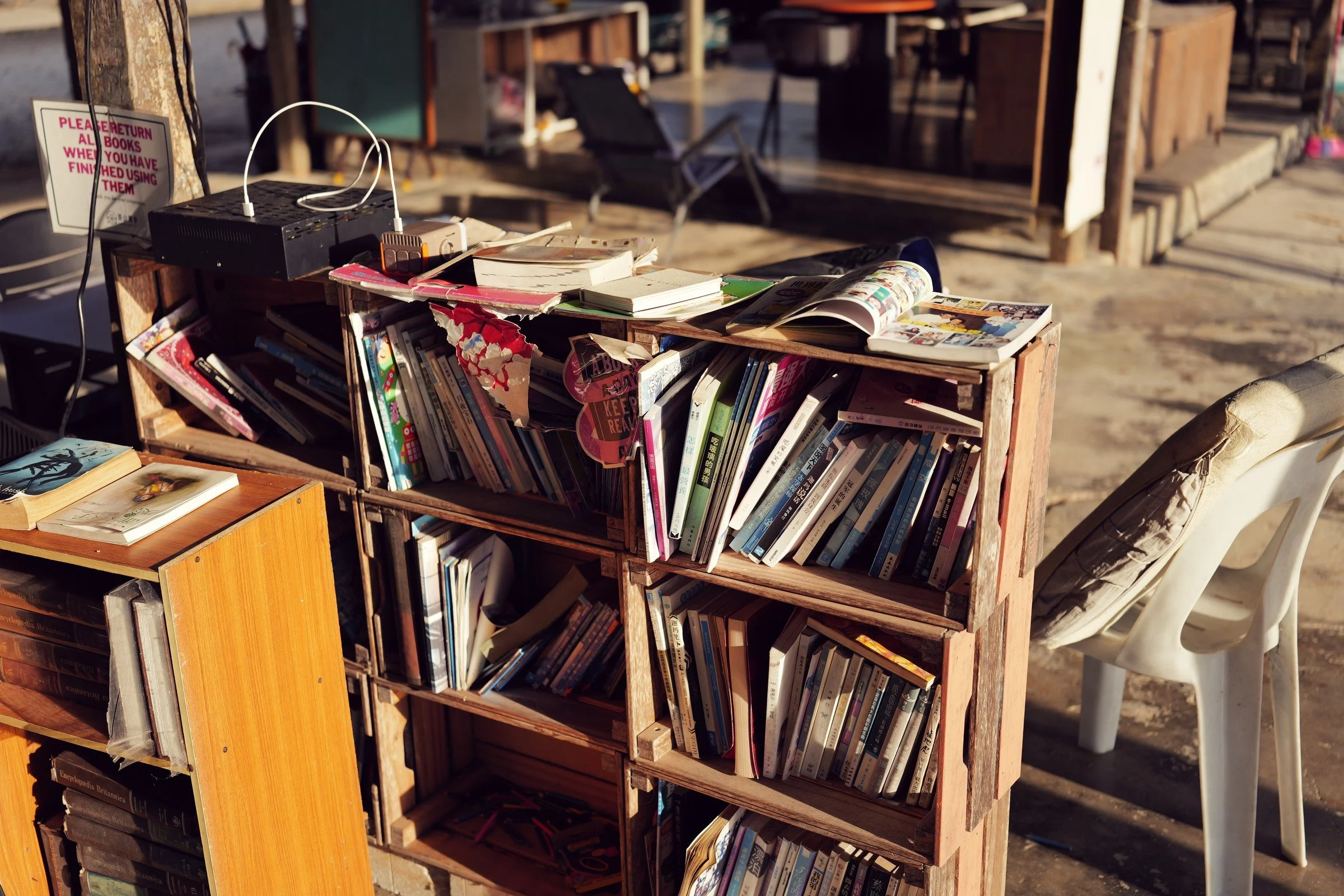 Small wooden bookshelves stand in a sunlit common area.