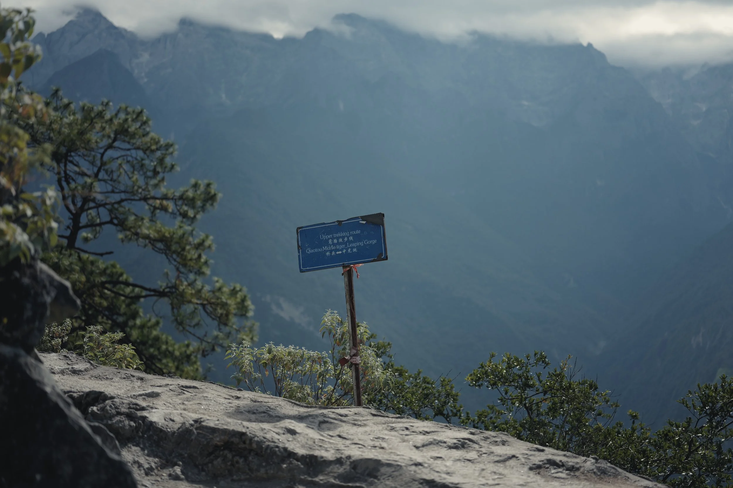 Hiking trail sign overlooking the mountains of Tiger Leaping Gorge, Yunnan