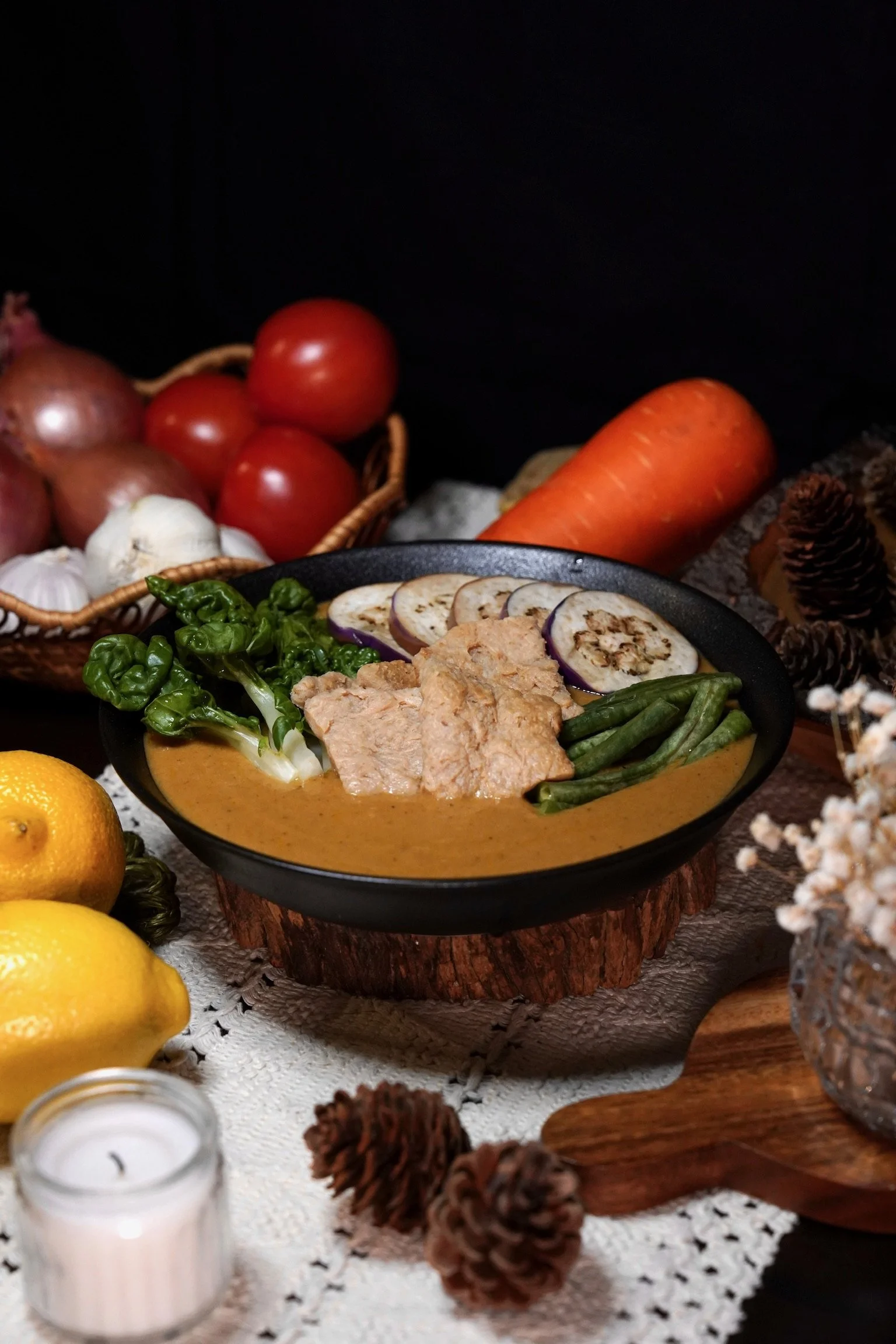 A bowl of Kare-Kare or peanut stew with green beans, eggplant, bok choy and soy slices.