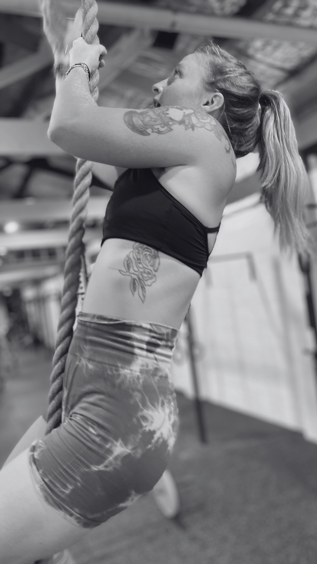 woman with tattoos completing a robe climb inside crossfit st kilda
