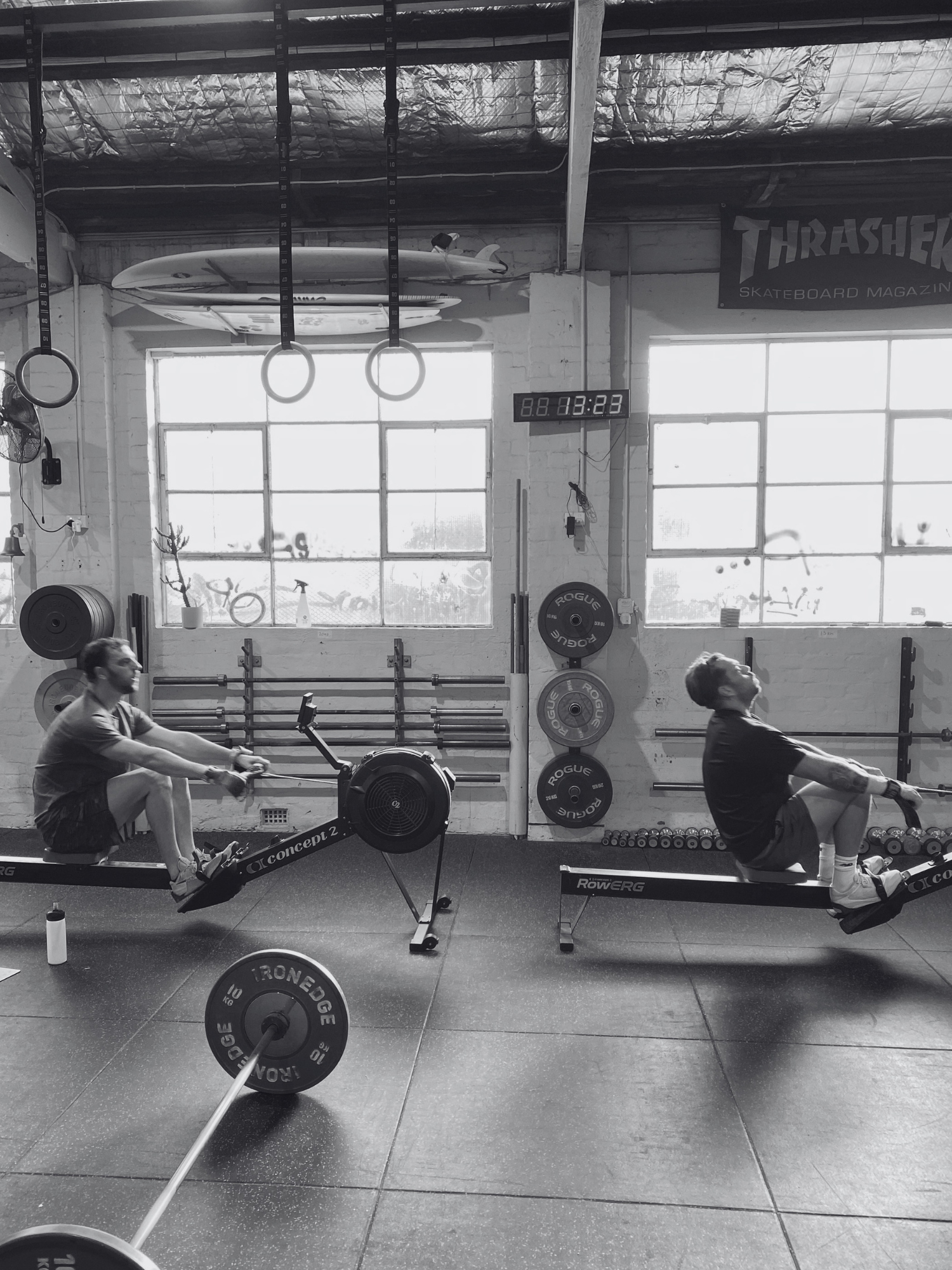 two men rowing inside stance training during a strength and conditioning workout