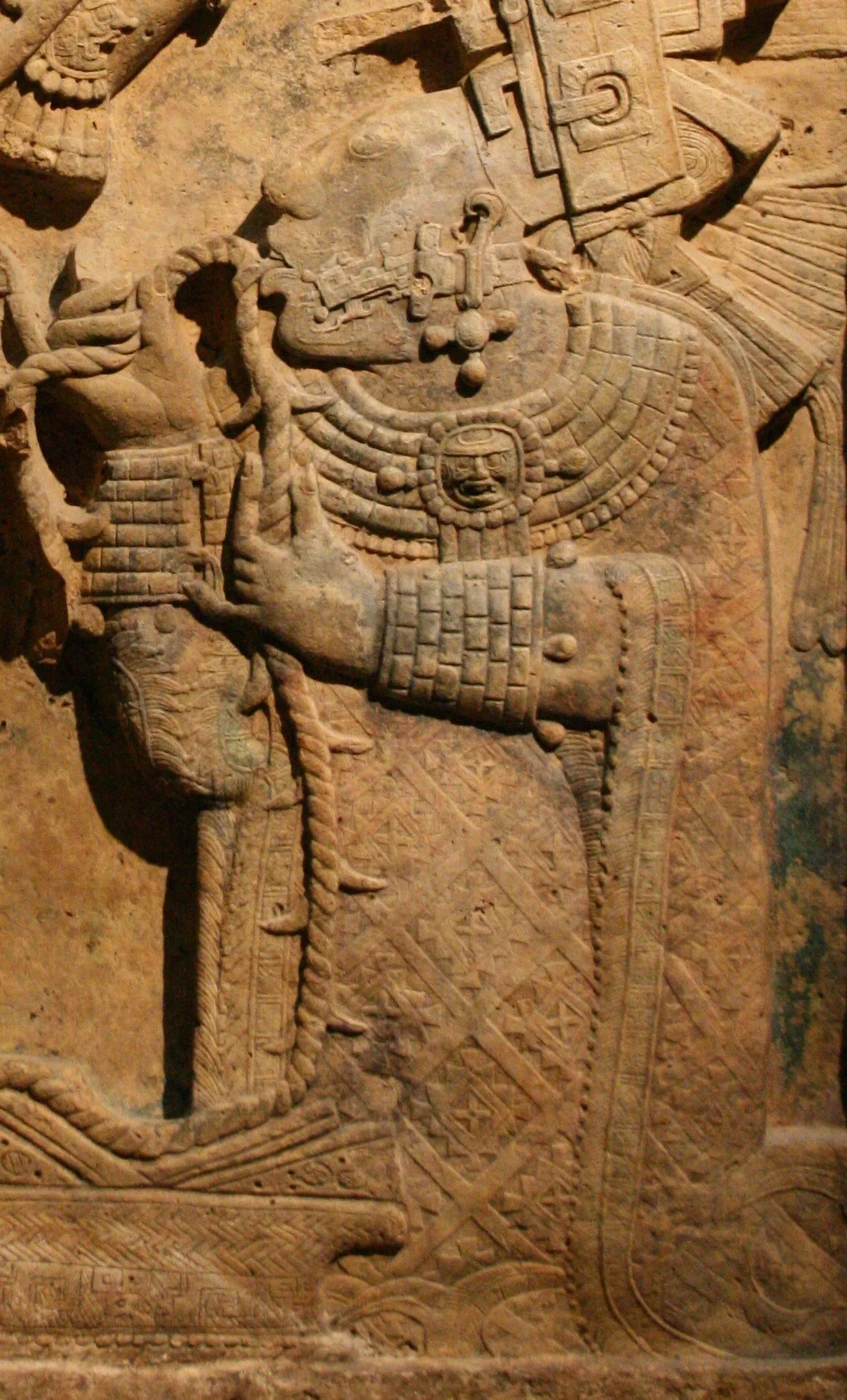Close up of ancient stone carving  depicting  Lady Xook of Yaxchilan, an ancient Maya woman, wearing huipil featuring the Rhomboid found in Papalotl Clothing's Tzotzil Mayan Embroidered huipil from Larrainzar Chiapas