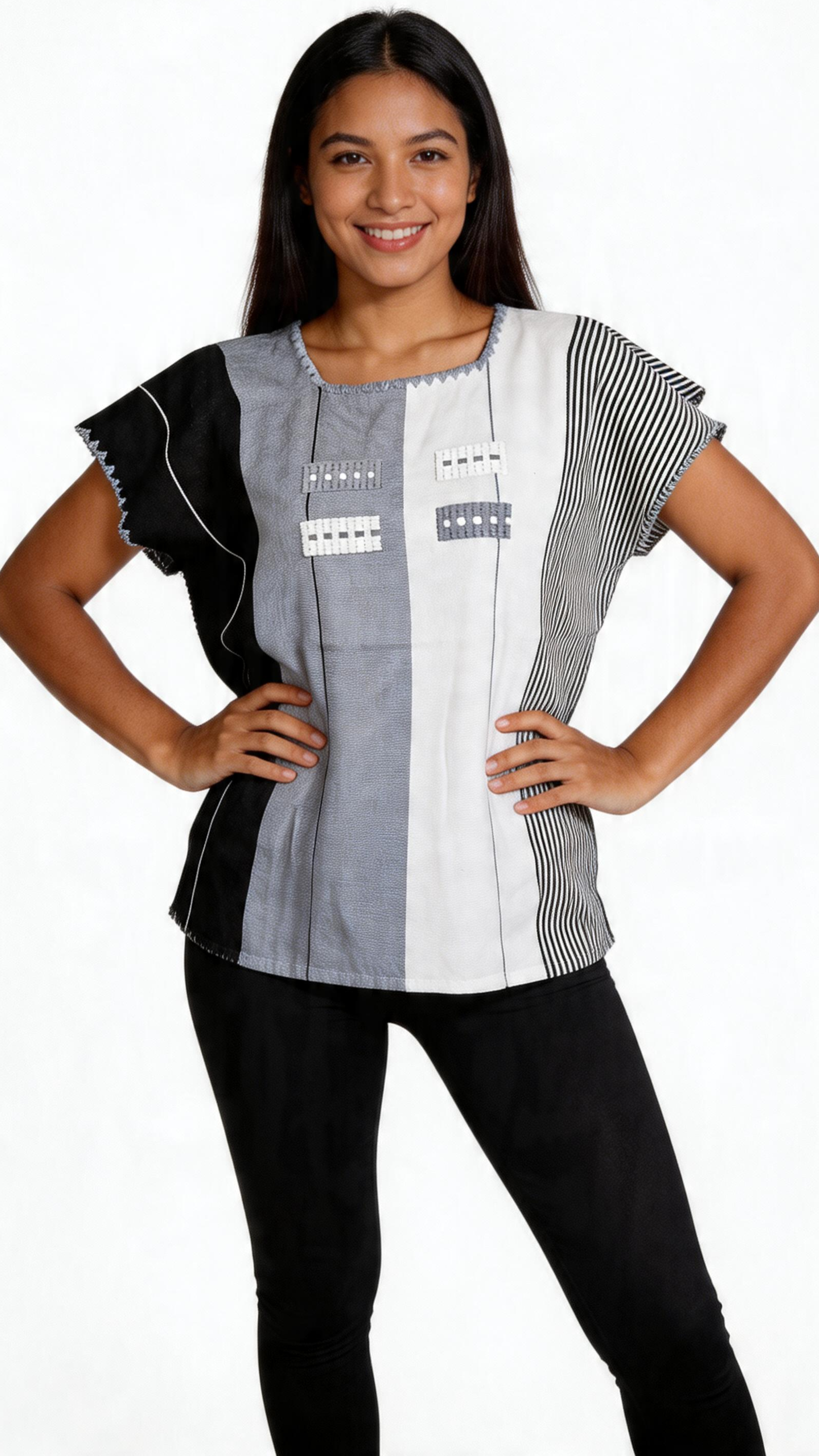 Woman with long dark hair smiling with hands on hips, wearing a black and white patterned short-sleeve top and black pants, posing against a plain white background.