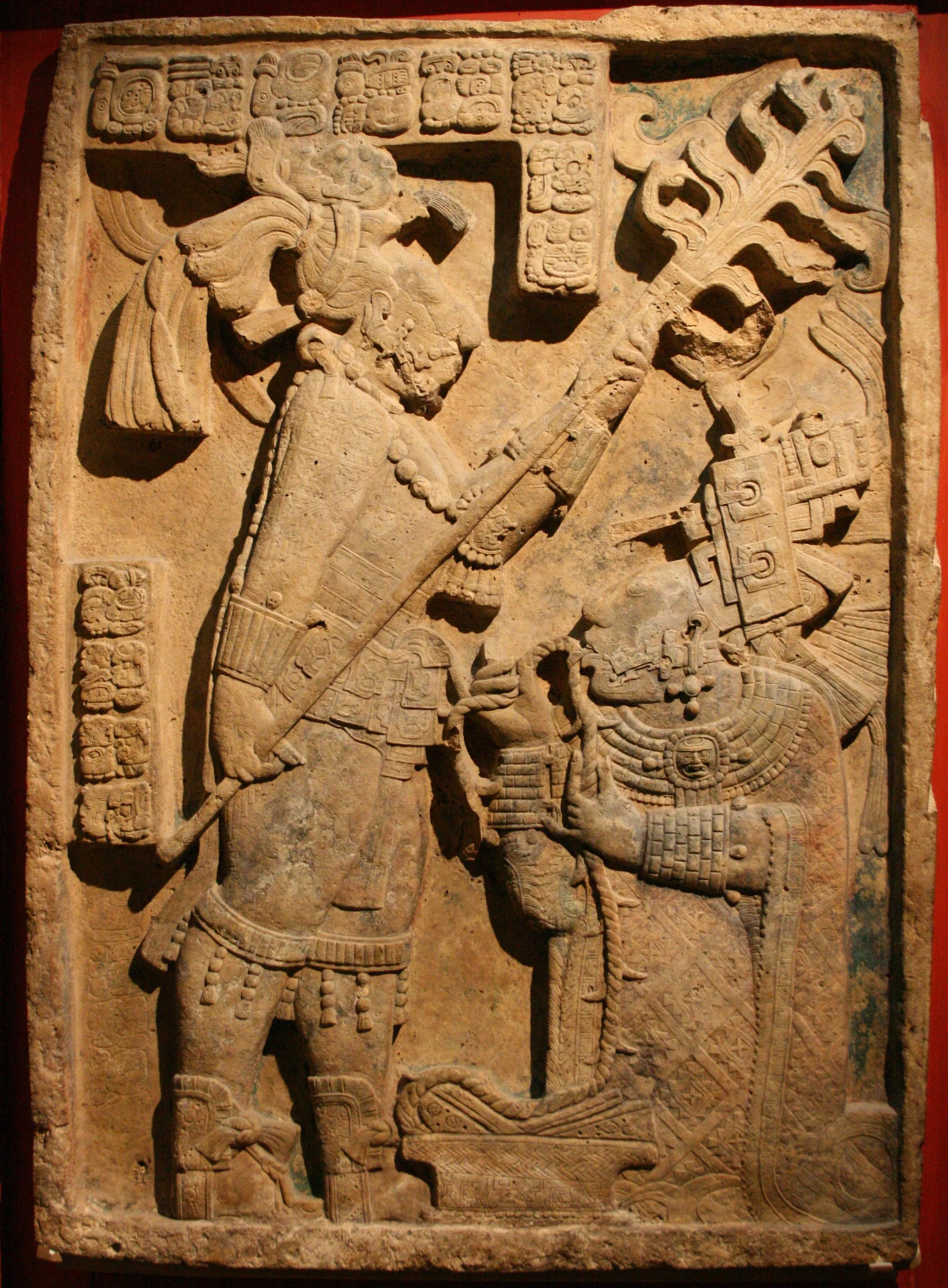 Ancient Mayan stone carving depicting  Lady Xook of Yaxchilan, an ancient Maya woman, wearing elaborate traditional attire that features the Rhomboid found in Papalotl Clothing's Tzotzil Mayan Embroidered huipil from Larrainzar Chiapas