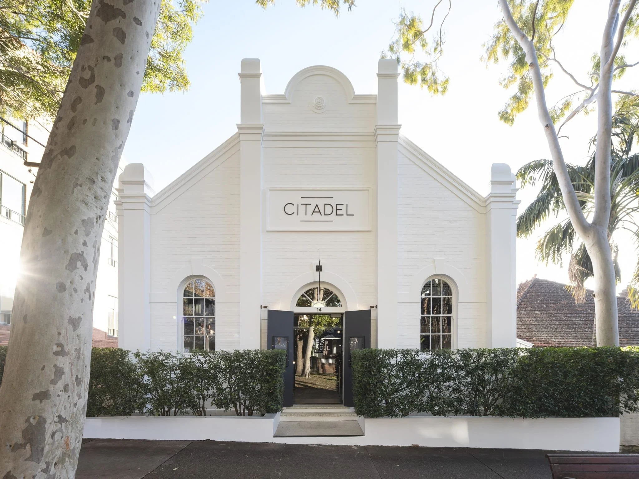 Front view of a white building labeled