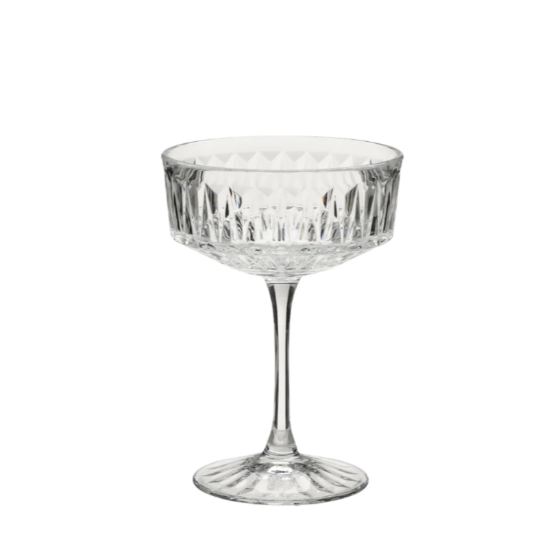 A clear crystal cocktail glass with a cut pattern, empty, against a white background.