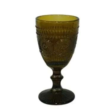 A decorative green glass goblet with intricate patterns and a short stem.