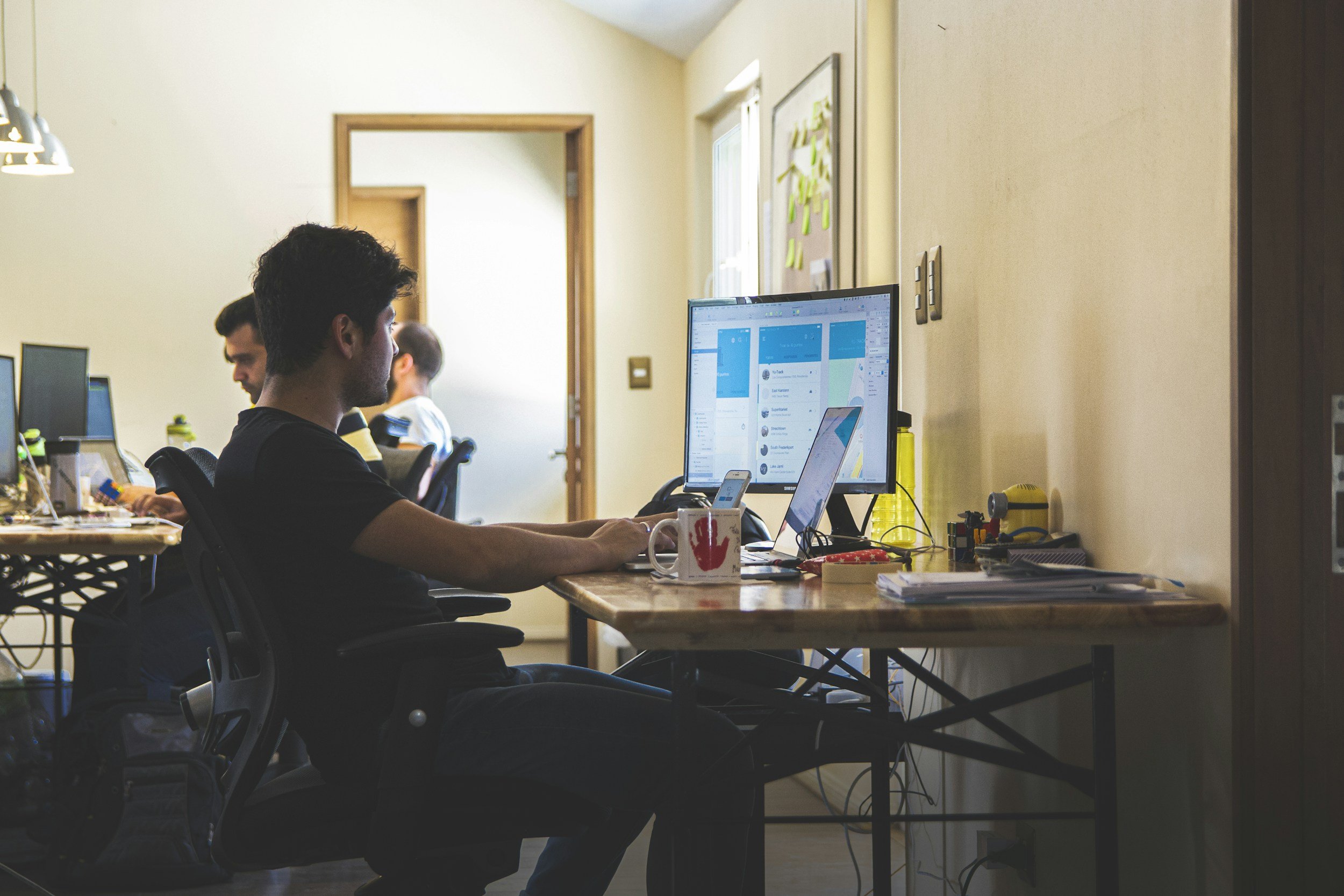 Team member at desk working on a computer manually moving information between systems that could be automated using Tram AI