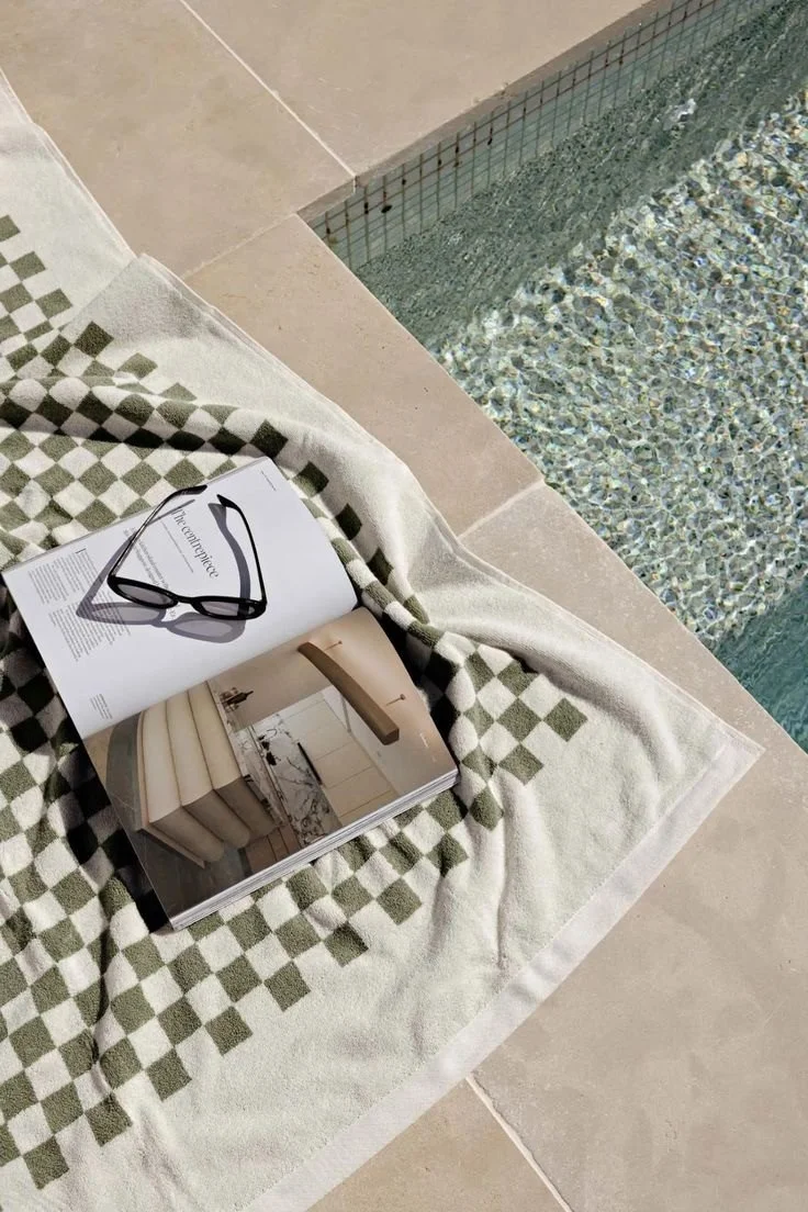 Poolside styling detail with towel and sunglasses — holiday rental styled by Terra Styling