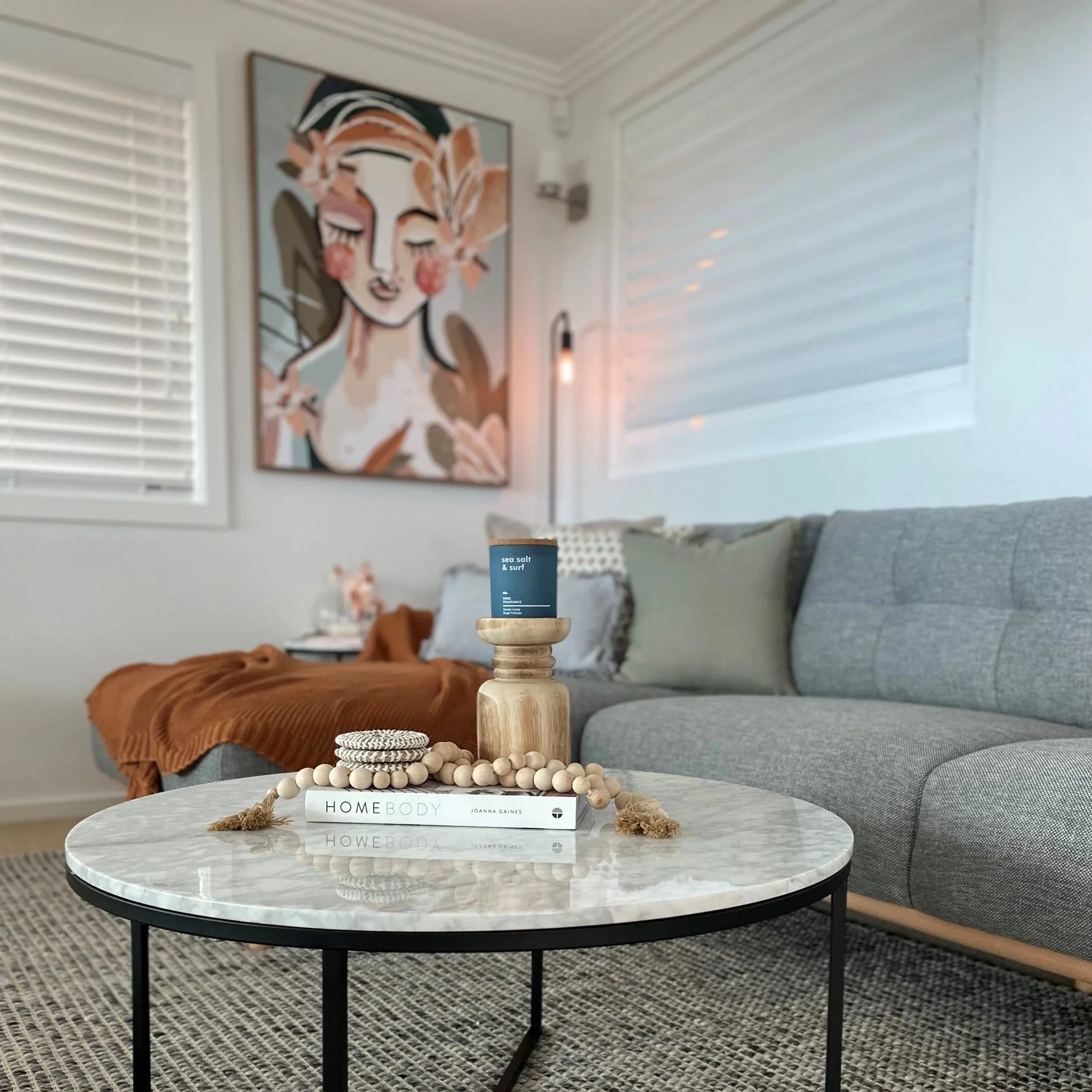 Coffee table detail with styling books, candle, and jute twine by Terra Styling — holiday rental