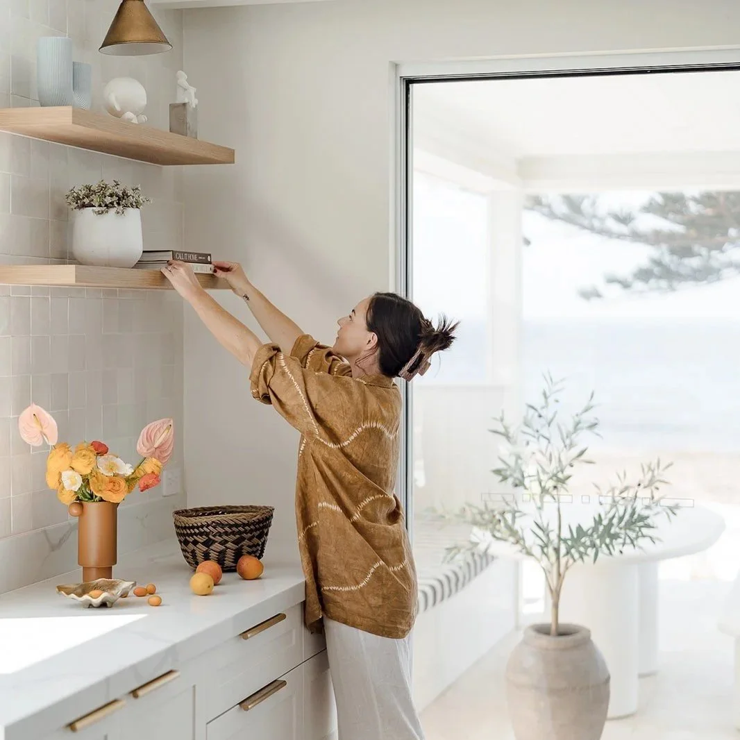 Interior stylist Kate Kilday arranging flowers in a coastal kitchen — Terra Styling, Kiama NSW