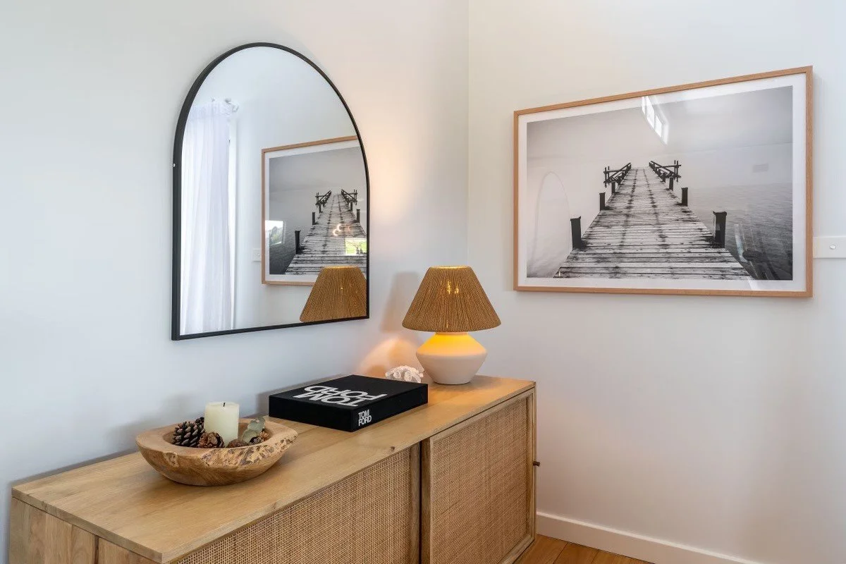 Entryway console with table lamp, framed coastal print, and mirror styled by Terra Styling — Kiama