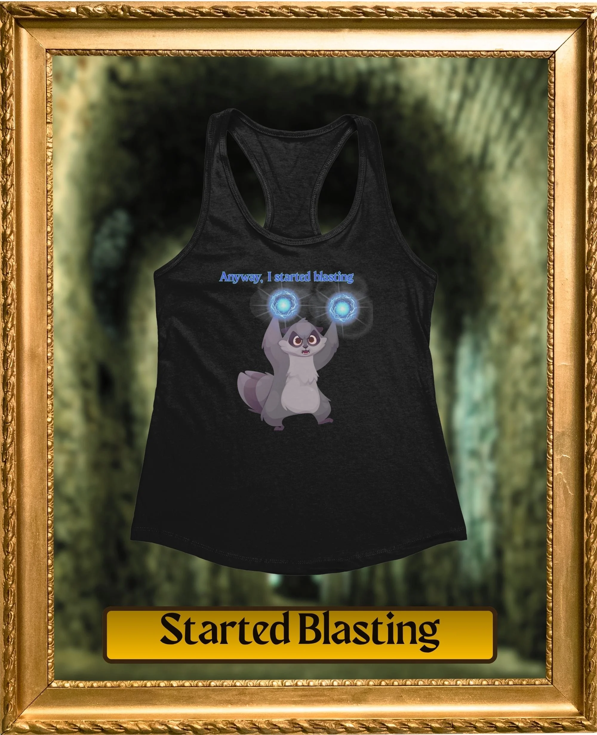 A black tank top with a cartoon of a raccoon holding two glowing blue orbs and the text "Anyway, I started blasting" on it, framed and hanging on a wall with a green, blurry forest background.
